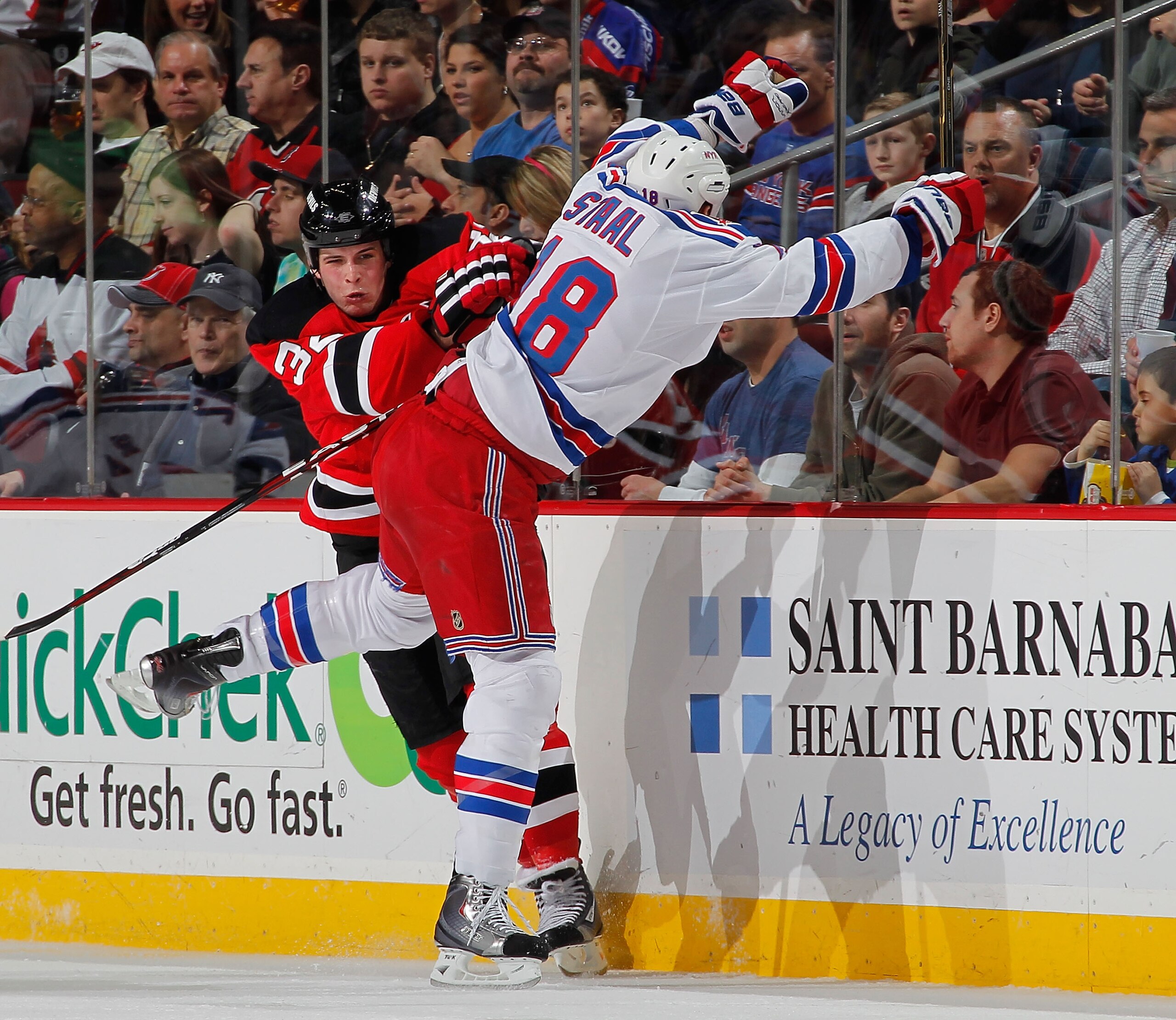 NEWARK, NJ - FEBRUARY 18:  Nick Palmieri #32 of the New Jersey Devils checks Marc Staal #18 of the New York Rangers during the second period of an NHL hockey game at the Prudential Center on February 18, 2011 in Newark, New Jersey.  (Photo by Paul Bereswi