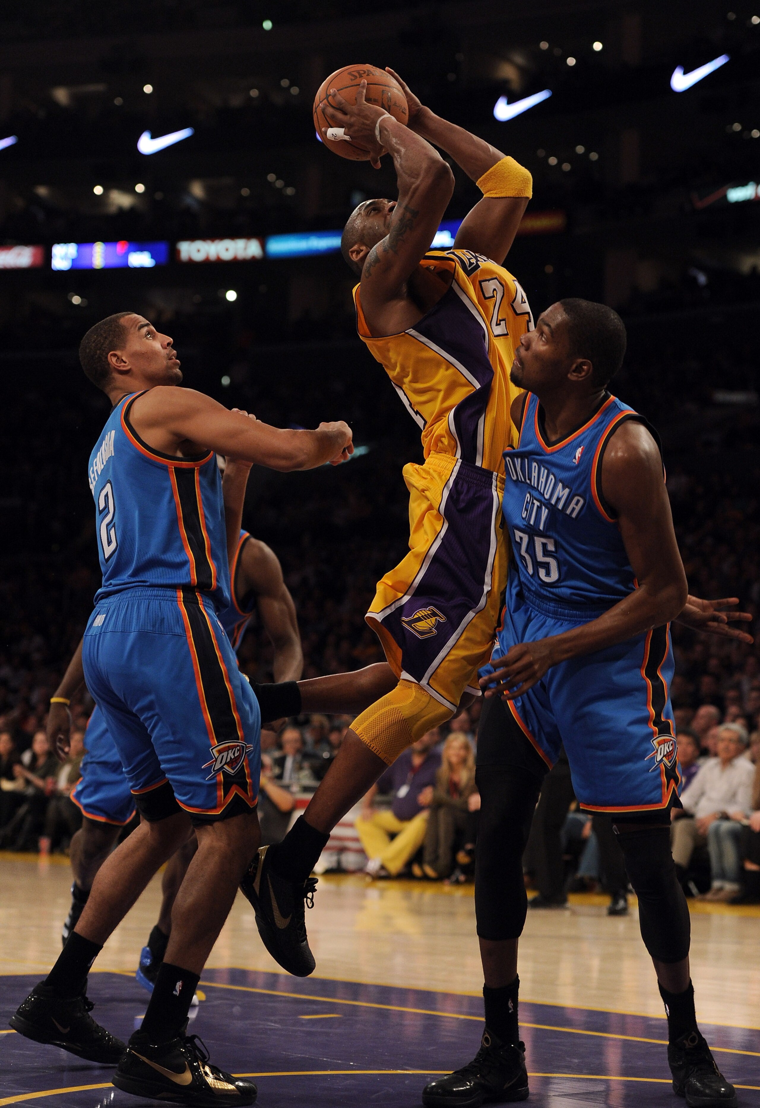 LOS ANGELES, CA - JANUARY 17:  Kobe Bryant #24 of the Los Angeles Lakers goes in for a layup past Thabo Sefolosha #2 and Kevin Durant #35 of the Oklahoma City Thunder at the Staples Center on January 17, 2011 in Los Angeles, California.  (Photo by Harry H