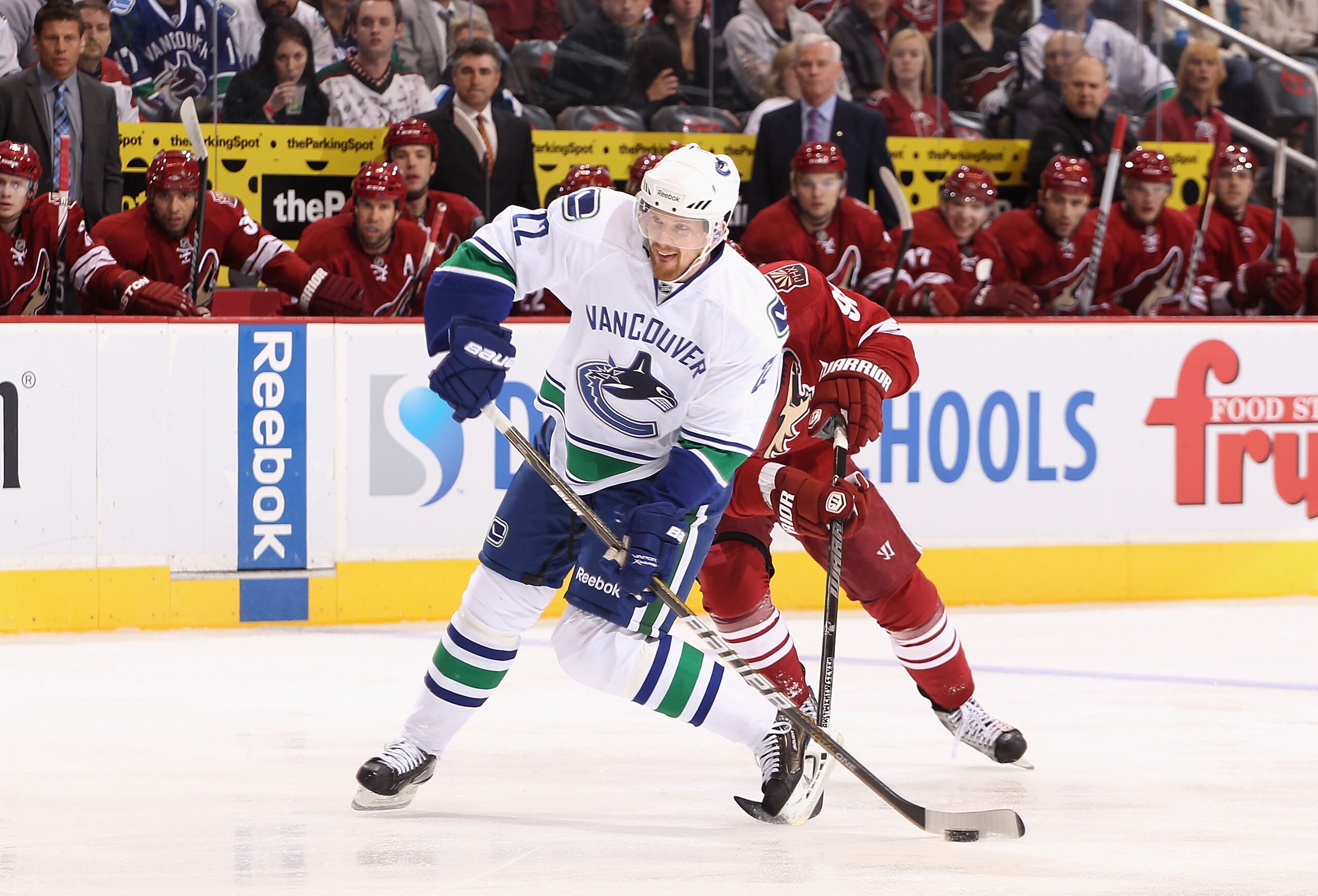 GLENDALE, AZ - FEBRUARY 02:  Daniel Sedin #22 of the Vancouver Canucks shoots the puck under pressure from Kyle Turris #91 of the Phoenix Coyotes during the NHL game at Jobing.com Arena on February 2, 2011 in Glendale, Arizona.  (Photo by Christian Peters
