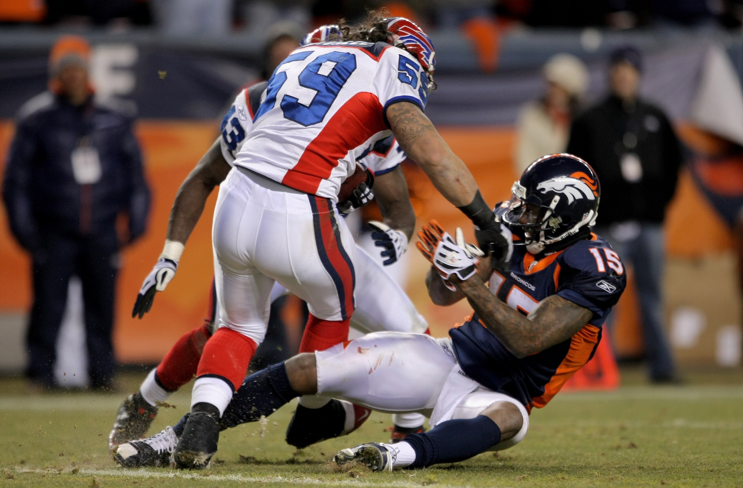 DENVER - DECEMBER 21:  Linebacker Kawika Mitchell #59 of the Buffalo Bills makes an interception of a Jay Culter pass late in the fourth quarter as intended receiver Brandon Marshall #15 of the Denver Broncos makes the tackle on the two yard line at Inves