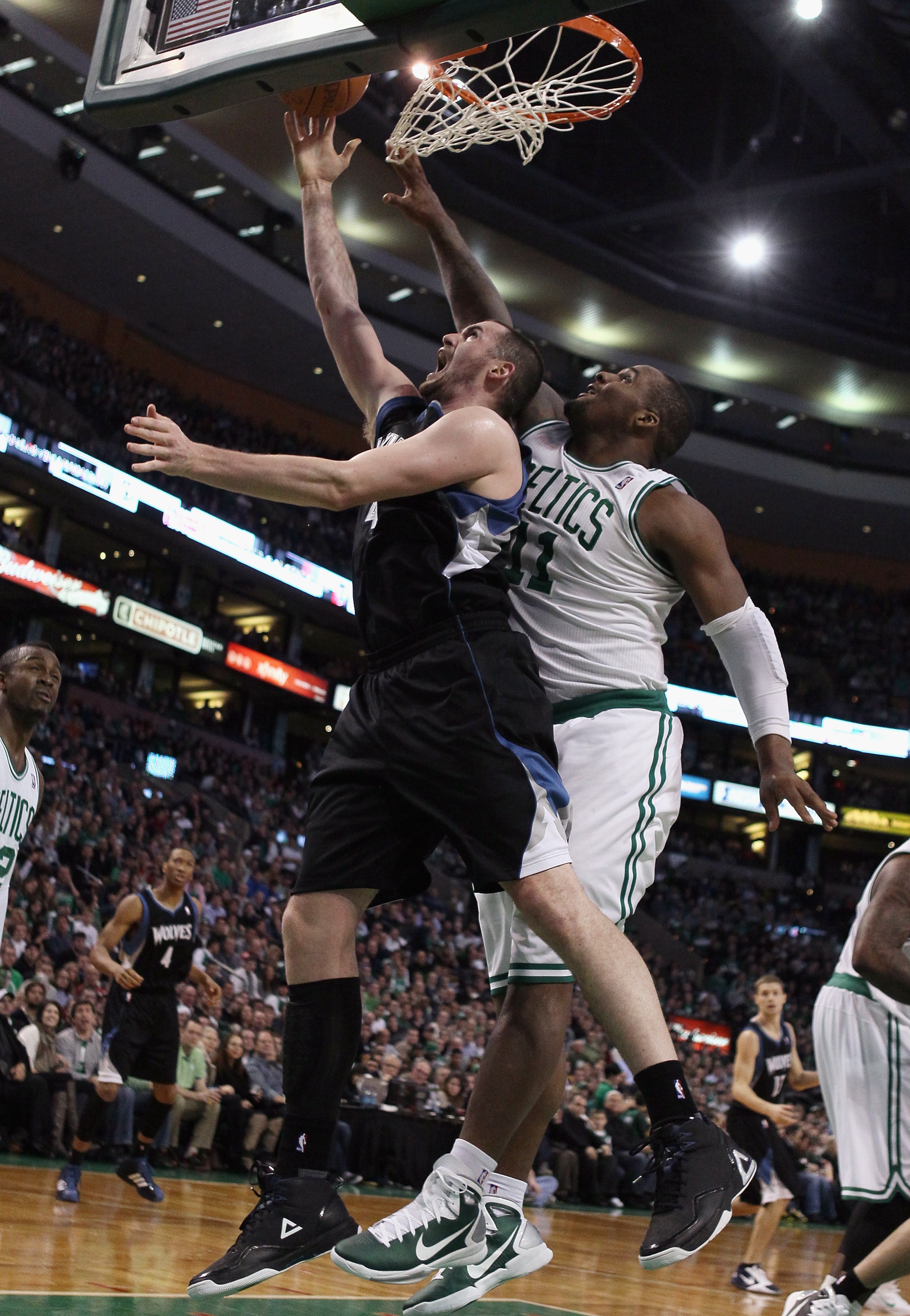 BOSTON, MA - JANUARY 03:  Kevin Love #42 of the Minnesota Timberwolves takes a shot as Glen Davis #11 of the Boston Celtics defends on January 3, 2011 at the TD Garden in Boston, Massachusetts. NOTE TO USER: User expressly acknowledges and agrees that, by