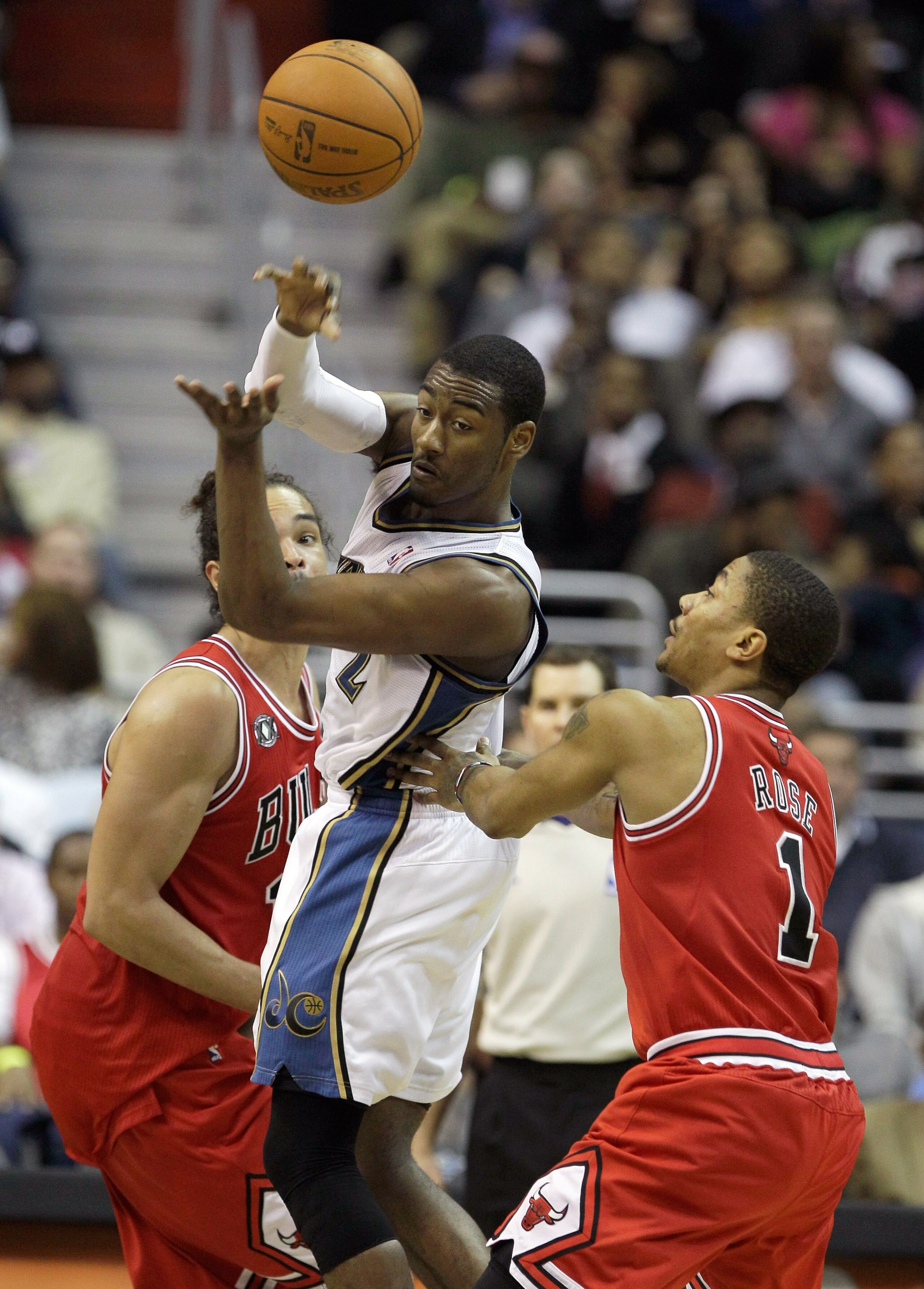 WASHINGTON, DC - FEBRUARY 28: John Wall #2 of the Washington Wizards passes the ball off while being guarded by Joakim Noah #13 (L) and Derrick Rose #1 of the Chicago Bulls at the Verizon Center in Washington on February 28, 2011 in Washington, DC. NOTE T