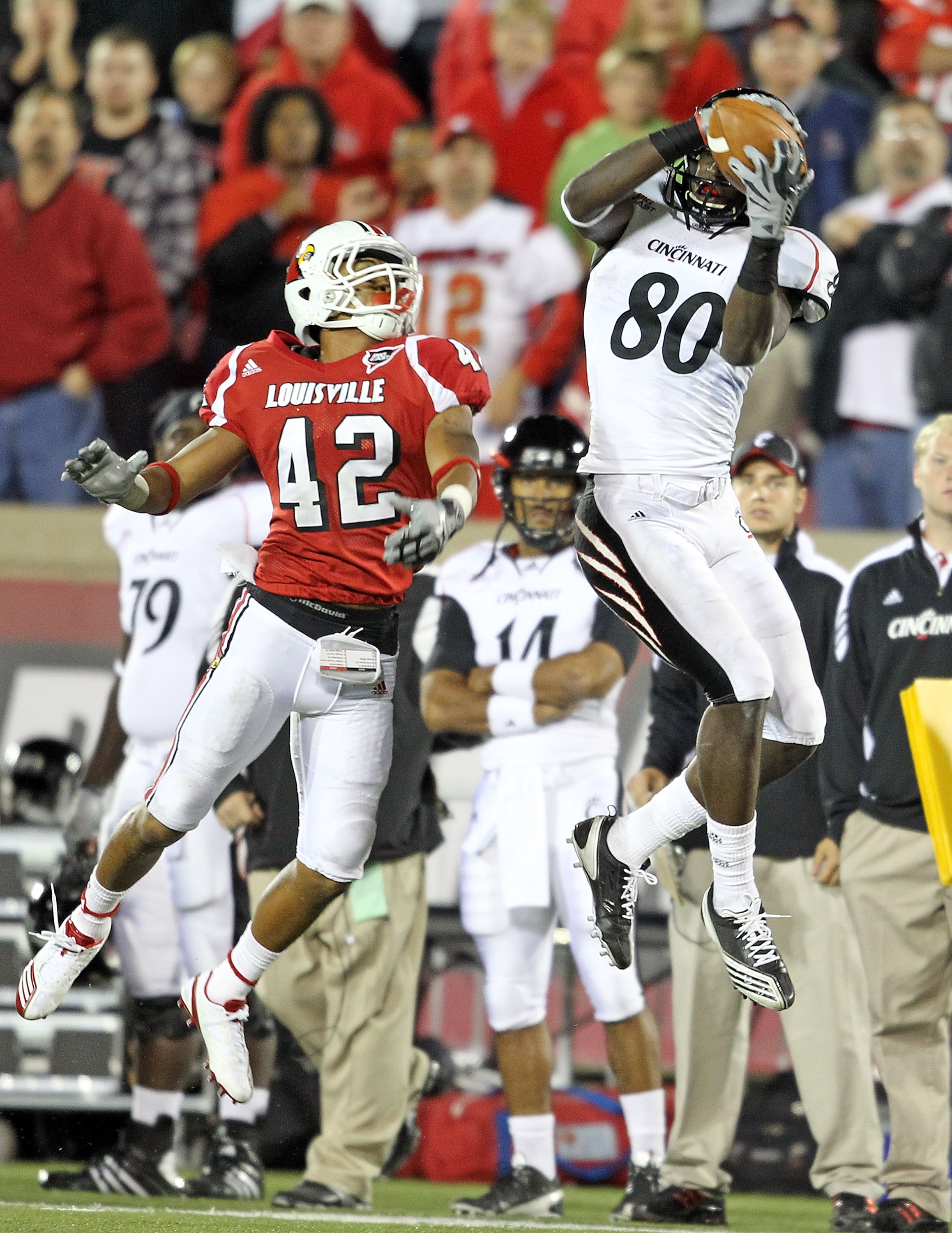 LOUISVILLE, KY - OCTOBER 15: Armon Binns # 80 of the Cincinnati Bearcats catches a touchdown pass during the Big East Conference game while defended by Bobby Burns #42 of the Louisville Cardinals at Papa John's Cardinal Stadium on October 15, 2010 in Lou