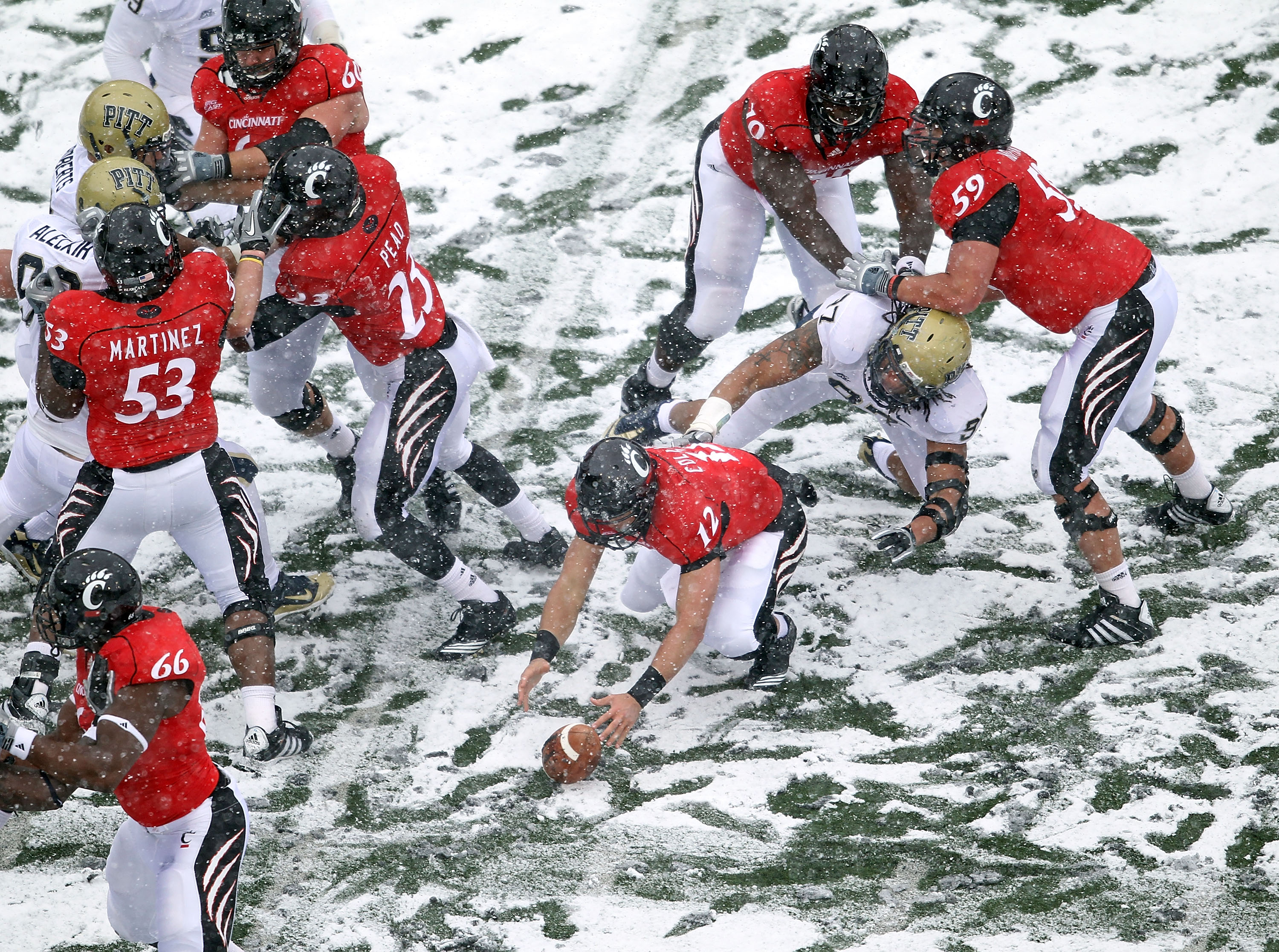 CINCINNATI, OH - DECEMBER 04: Zach Collaros #12 of the Cincinnati Bearcats reaches for a fumble during the Big East Conference game against the Pittsburgh Panthers at Nippert Stadium on December 4, 2010 in Cincinnati, Ohio. Pittsburgh won 28-10. (Photo