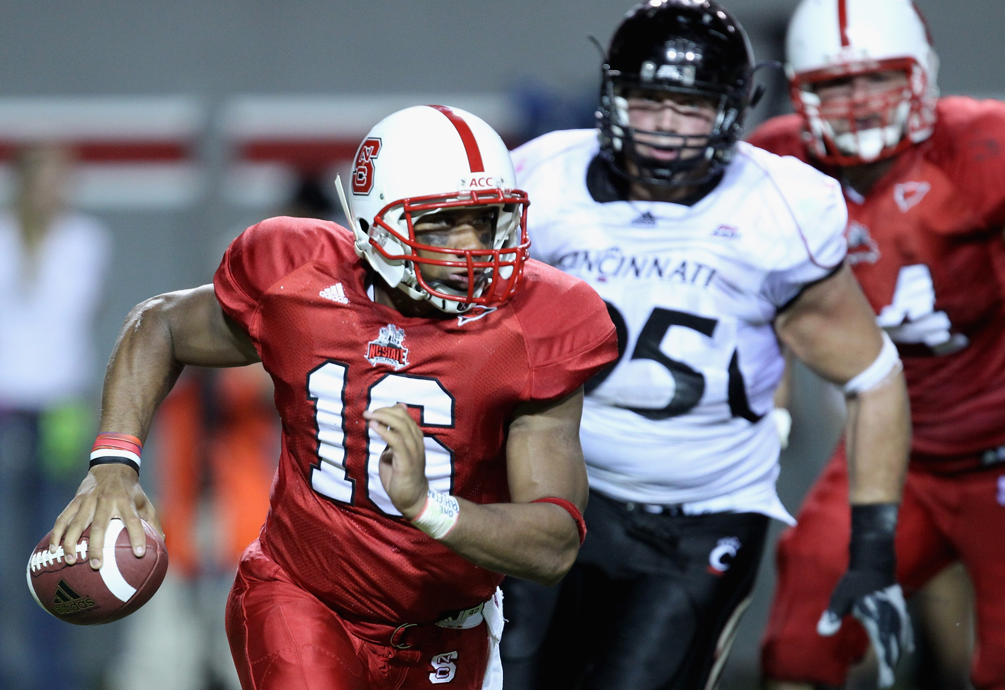 RALEIGH, NC - SEPTEMBER 16: Derek Wolfe #95 of the Cincinnati Bearcats tries to chase down Russell Wilson #16 of the North Carolina State Wolfpack during their game at Carter-Finley Stadium on September 16, 2010 in Raleigh, North Carolina. (Photo by Str