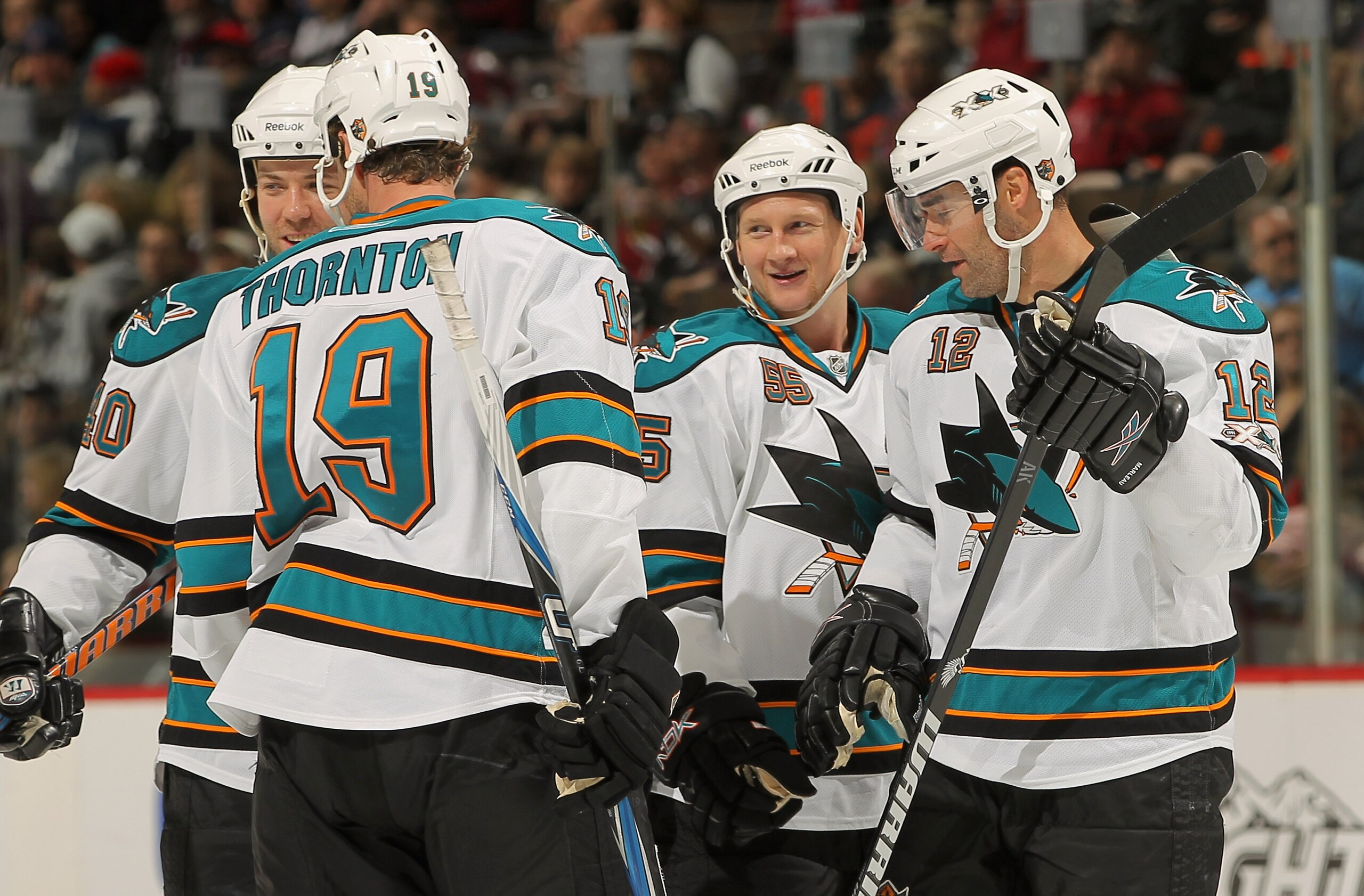 DENVER - NOVEMBER 17:  Mike Moore #55 (2nd R) of the San Jose Sharks celebrates his second period goal against the Colorado Avalanche with teammates Patrick Marleau #12, Joe Thornton #19 and Kent Huskins #40 at the Pepsi Center on November 17, 2010 in Den