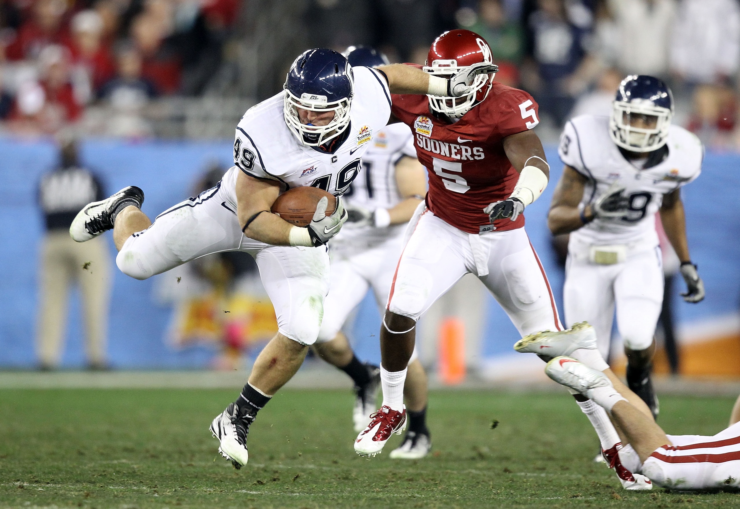 GLENDALE, AZ - JANUARY 01:  Anthony Sherman #49 of the Connecticut Huskies leaps in the fourth quarter against the Oklahoma Sooners in the fourth quarter during the Tostitos Fiesta Bowl at the Universtity of Phoenix Stadium on January 1, 2011 in Glendale,