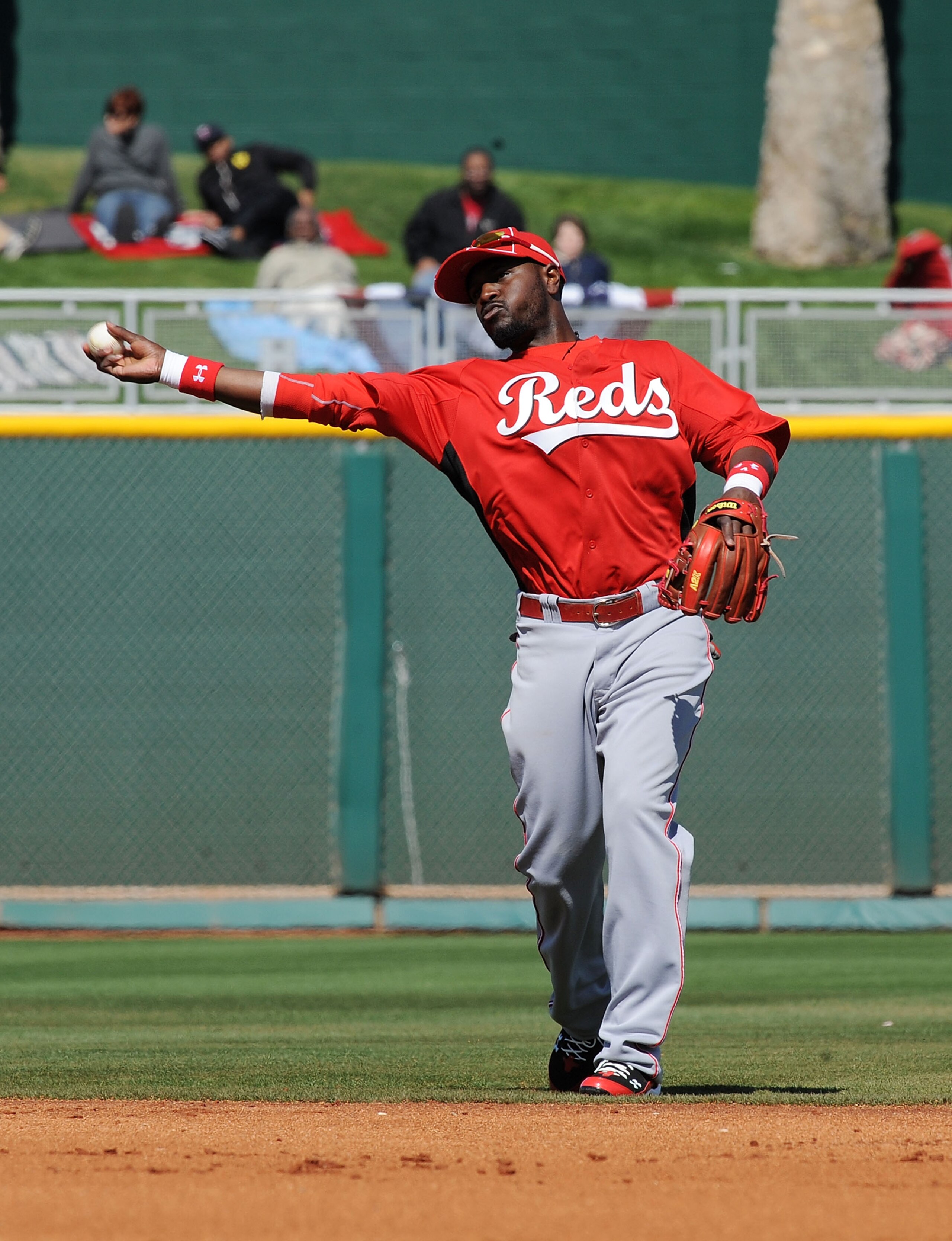 GOODYEAR, AZ - FEBRUARY 27:  Brandon Phillips #4 of the Cincinnati Reds throws the ball to first base during warm ups in between innings against the Cleveland Indians at Goodyear Ballpark on February 27, 2011 in Goodyear, Arizona.  (Photo by Norm Hall/Get