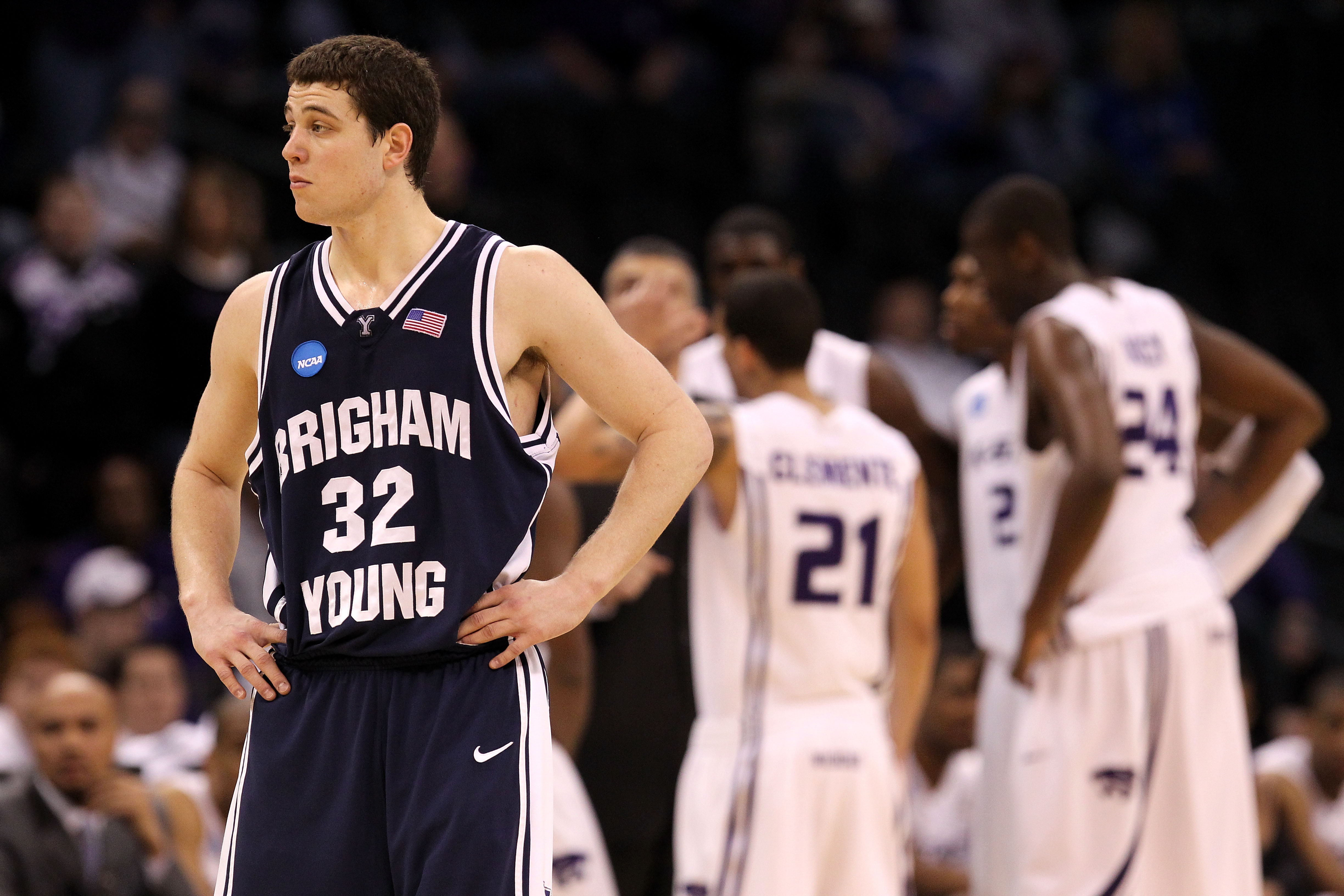 OKLAHOMA CITY - MARCH 20:  Jimmer Fredette #32 of the Brigham Young Cougars looks on as the Kansas State Wildcats huddle up in the background during the second round of the 2010 NCAA men's basketball tournament at Ford Center on March 20, 2010 in Oklahoma