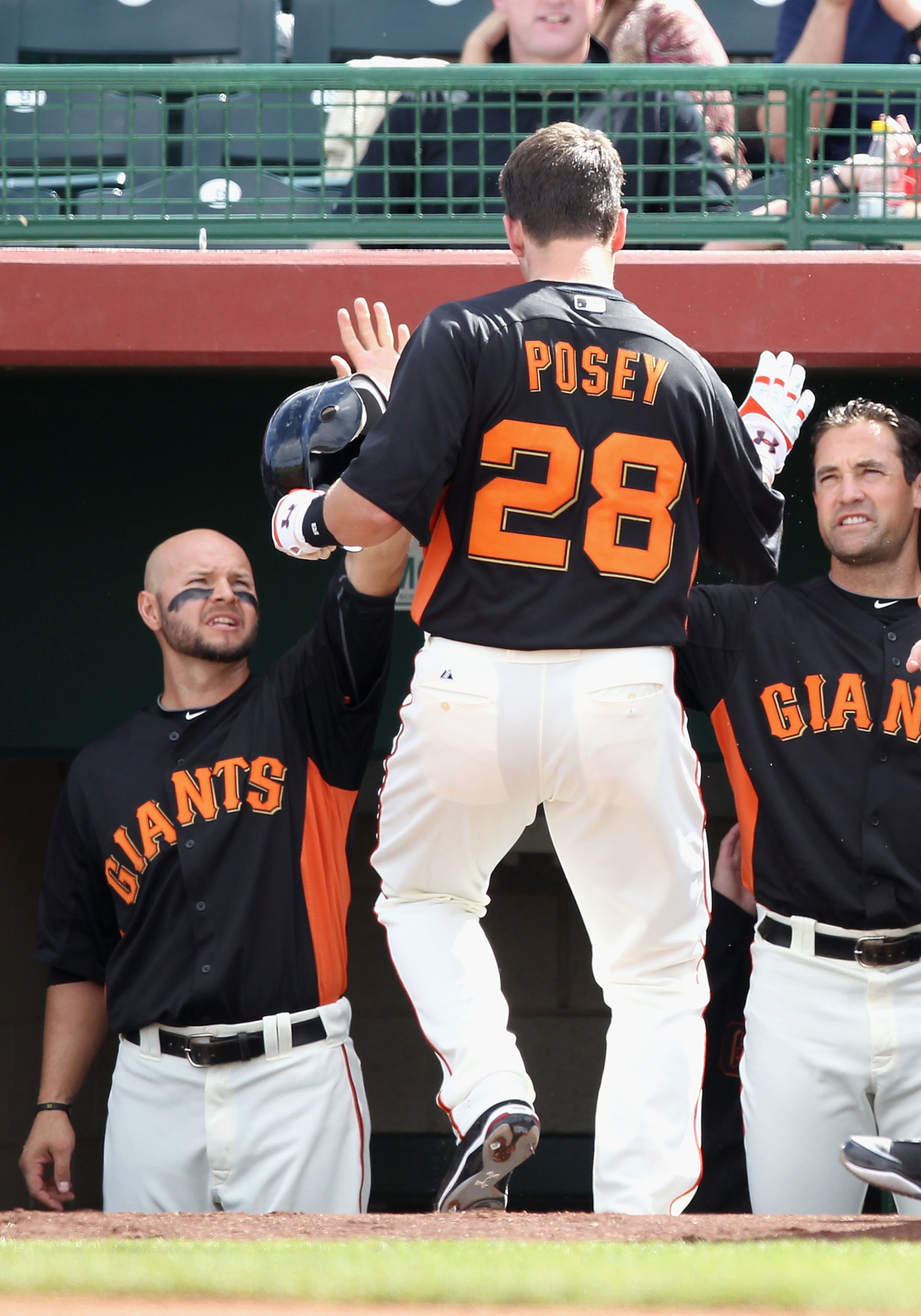 SCOTTSDALE, AZ - MARCH 01:  Buster Posey #28 of the San Francisco Giants is congratulated by teammates Cody Ross #13 (L) and Pat Burrell #5 (R) after Posey scored against the Chicago Cubs during the second inning of the spring training game at Scottsdale
