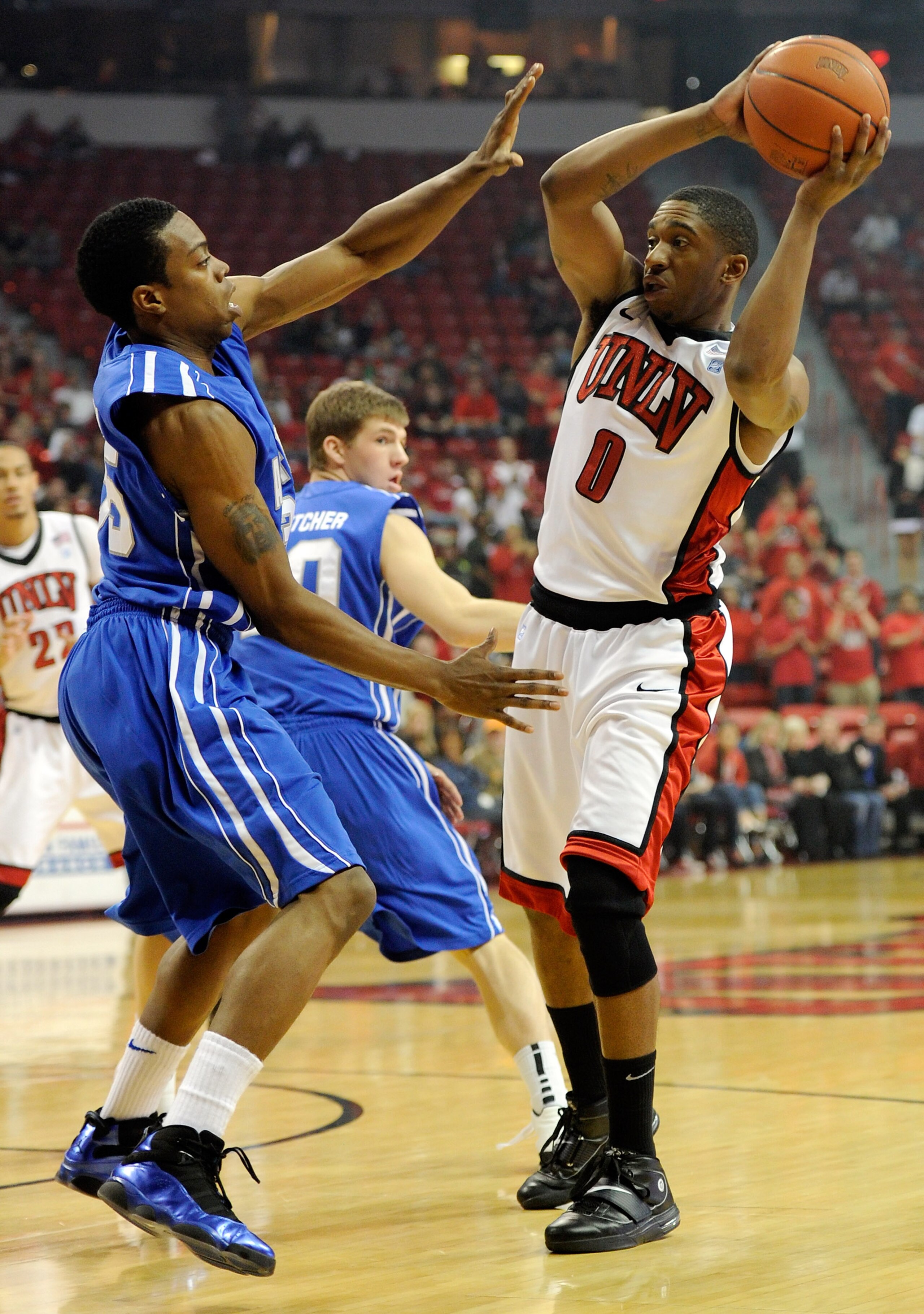 LAS VEGAS, NV - FEBRUARY 15:  Oscar Bellfield #0 of the UNLV Rebels looks to pass against Evan Washington #35 of the Air Force Falcons during their game at the Thomas & Mack Center February 15, 2011 in Las Vegas, Nevada. UNLV won 49-42.  (Photo by Ethan M