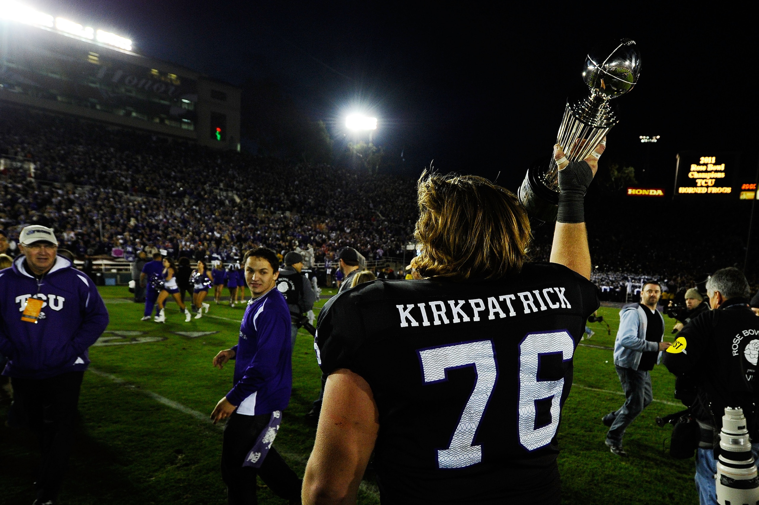 PASADENA, CA - JANUARY 01:  Center Jake Kirkpatrick #76 of the TCU Horned Frogs celebrates with the Rose Bowl Championship Trophy after defeating the Wisconsin Badgers 21-19 in the 97th Rose Bowl game on January 1, 2011 in Pasadena, California.  (Photo by