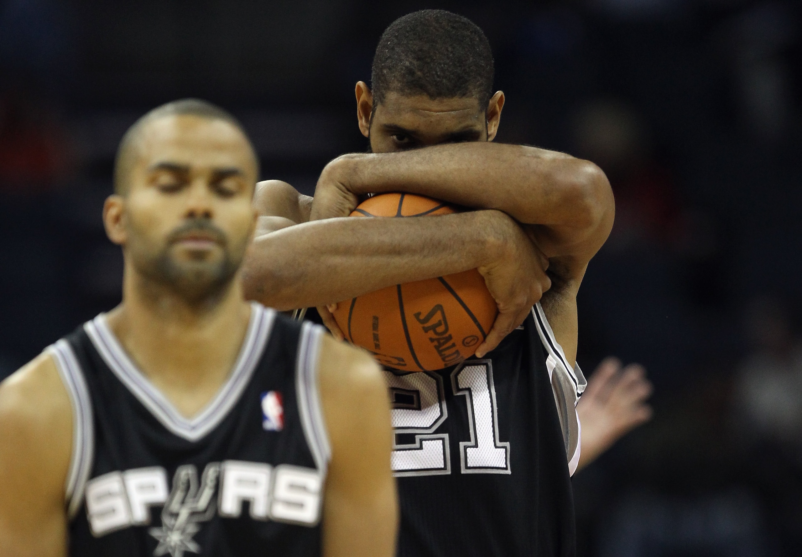 CHARLOTTE, NC - NOVEMBER 08:  Teammates Tony Parker #9 and Tim Duncan #21 of the San Antonio Spurs walk onto the court against the Charlotte Bobcats before their game at Time Warner Cable Arena on November 8, 2010 in Charlotte, North Carolina.  NOTE TO US