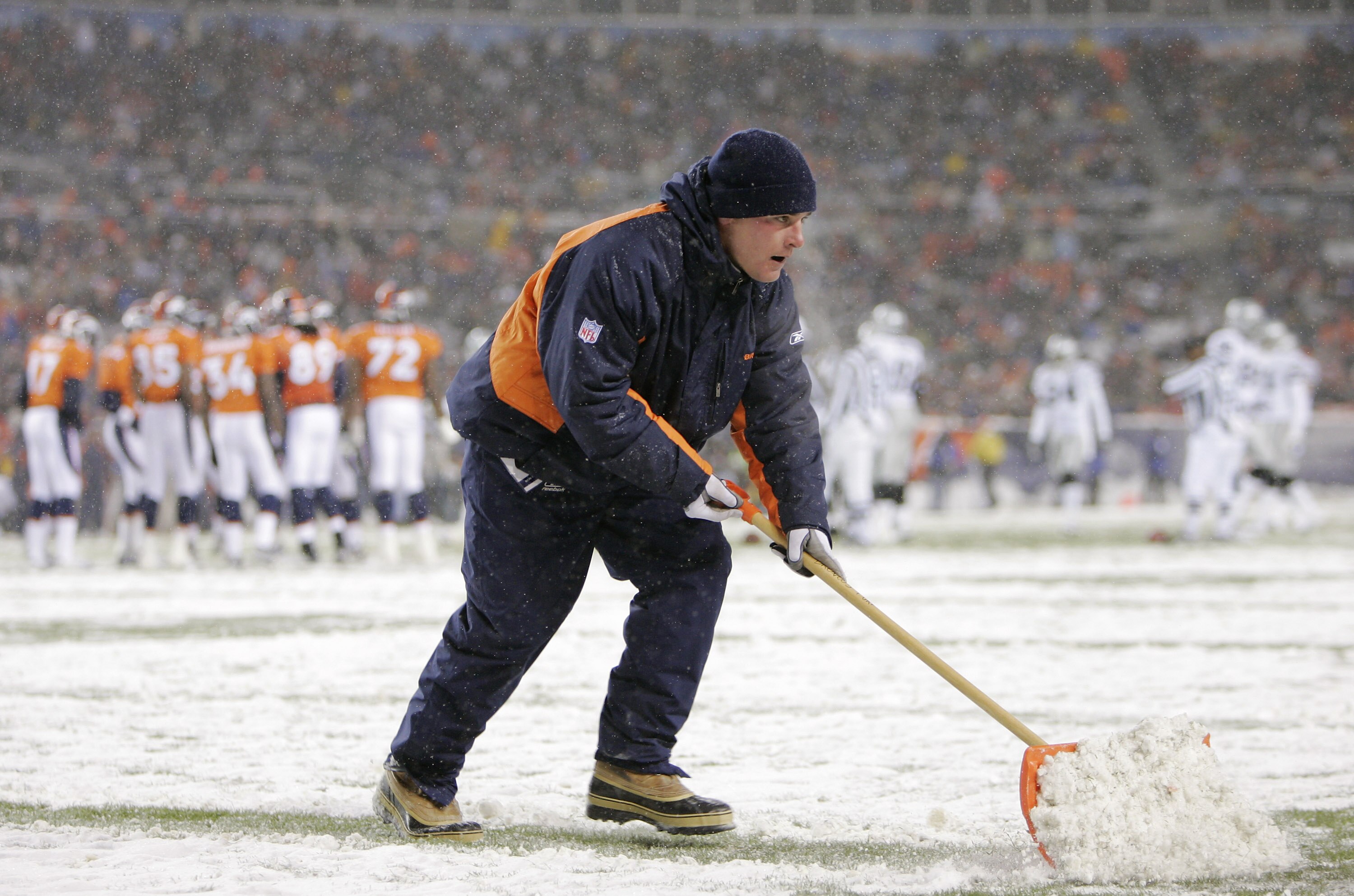 DENVER - NOVEMBER 28:  A member of the grounds crew shovels snow off a yard line during the game between the Oakland Raiders and the Denver Broncos on November 28, 2004 at Invesco Field at Mile High Stadium in Denver, Colorado.  The Raiders won 25-24.  (P