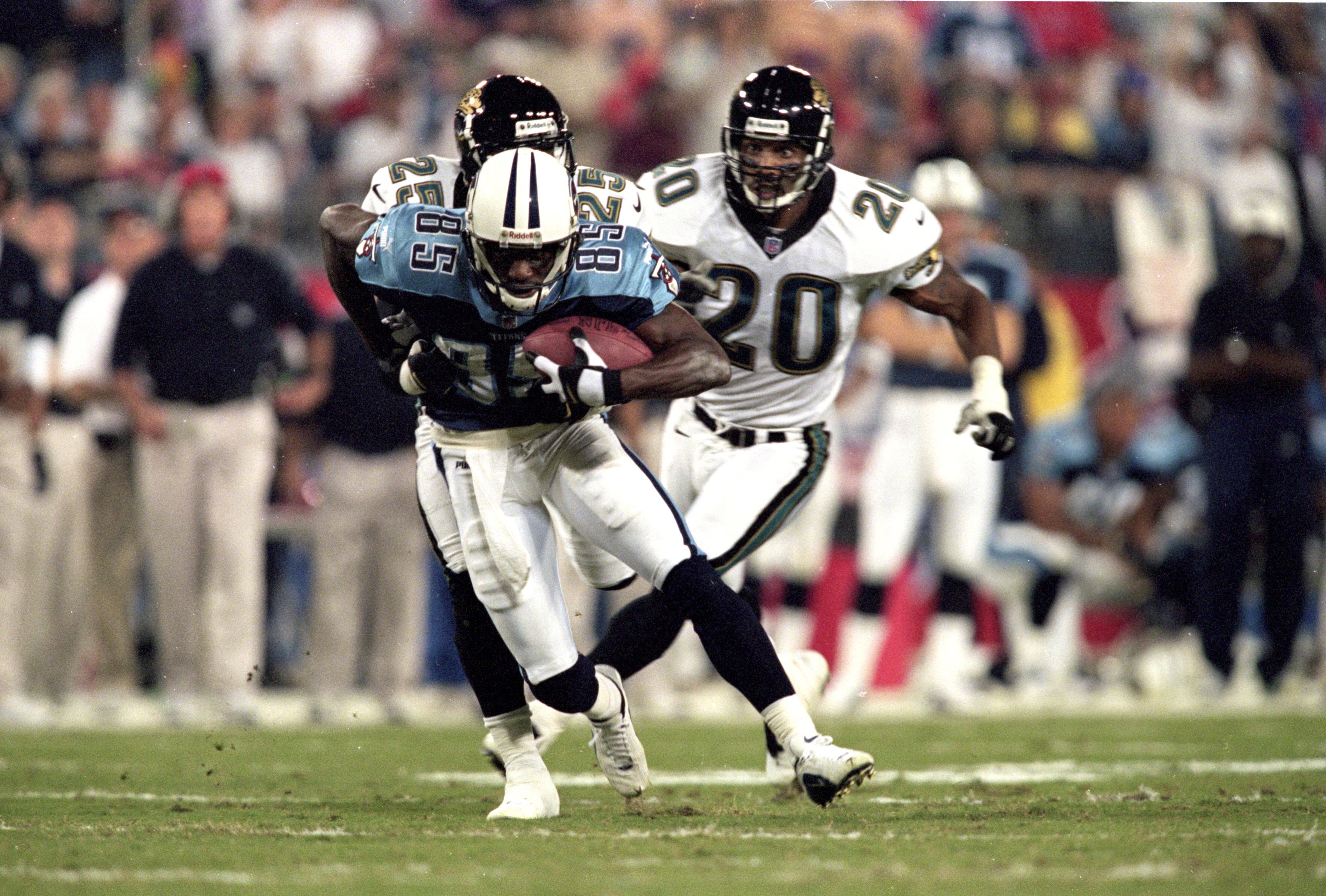 16 Oct 2000: Derrick Mason #85 of the Tennessee Titans gets pulled down by Fernando Bryant #25 and Donovin Darius #20 of the Jacksonville Jaguars during the game at Adelphia Coliseum in Nashville, Tennessee. The Titans defeated the Jaguars 27-13. Mandator