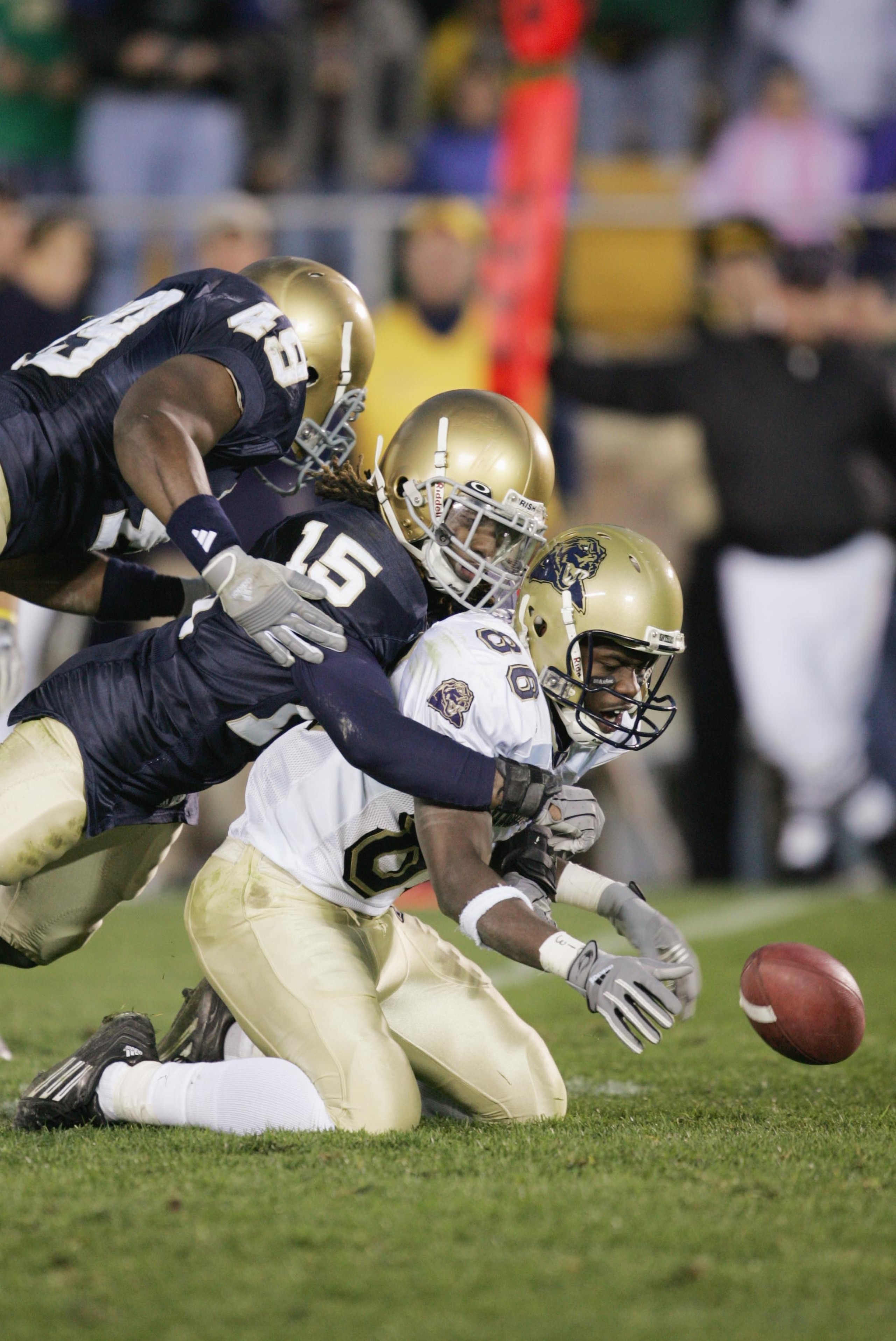 SOUTH BEND, IN - NOVEMBER 13:  Wide receiver Greg Lee #86 of the University of Pittsburgh Panthers is tackled by cornerback Preston Jackson #15 and linebacker Derek Curry #49 of the University of Notre Dame Fighting Irish during the game on November 13, 2