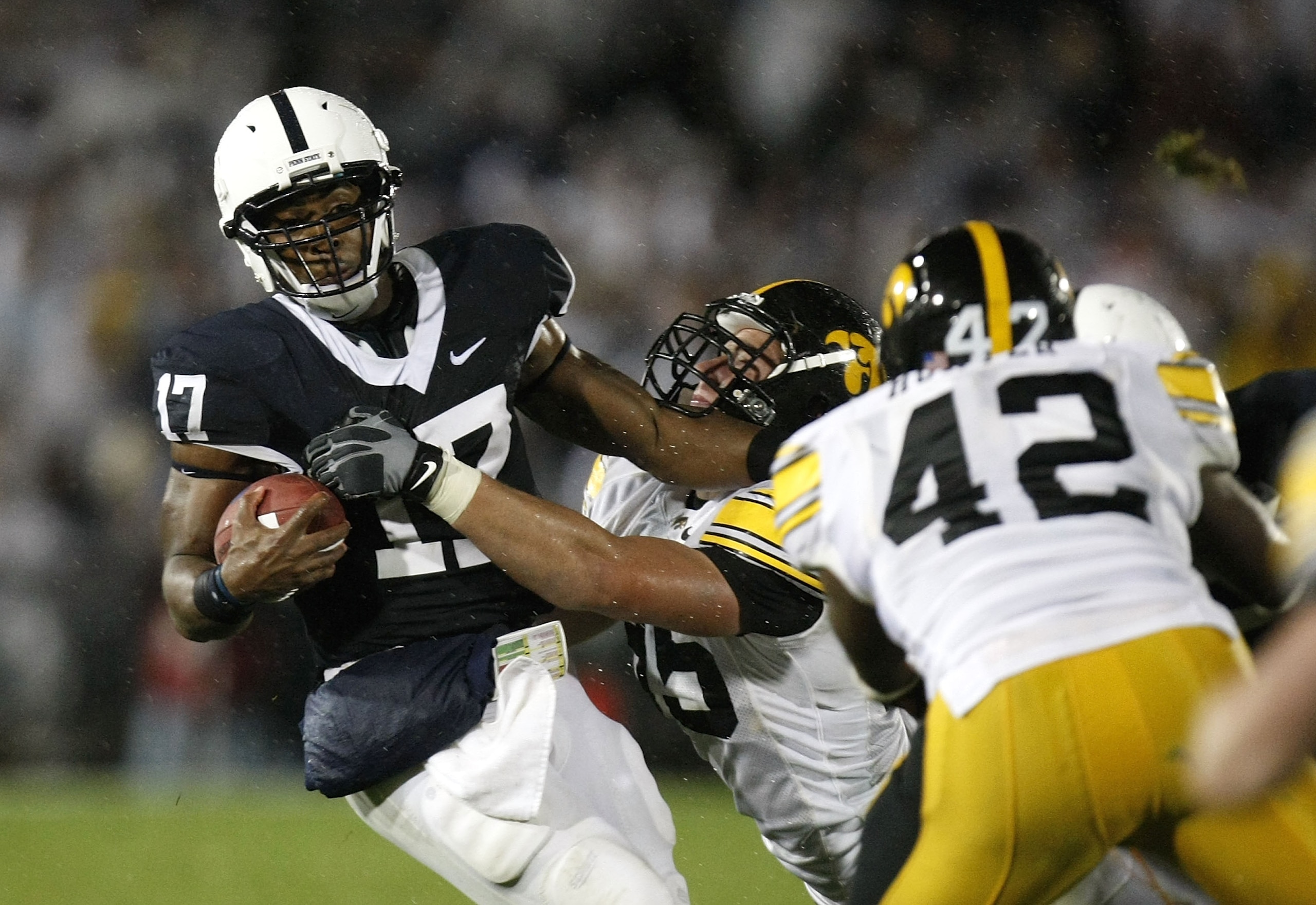 STATE COLLEGE, PA - SEPTEMBER 26:  Daryll Clark #17 of the Penn State Nittnay Lions is tackled by Karl Klug #95 and Jeremiha Hunter #42 of the Iowa Hawkeye's on September 26, 2009 at Beaver Stadium in State College, Pennsylvania.  (Photo by Gregory Shamus