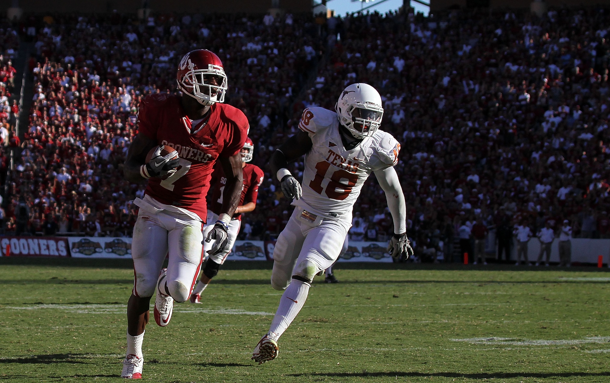 DALLAS - OCTOBER 02:  Running back Demarco Murray #7 of the Oklahoma Sooners runs past D.J. Grant #18 of the Texas Longhorns in the third quarter at the Cotton Bowl on October 2, 2010 in Dallas, Texas.  (Photo by Ronald Martinez/Getty Images)
