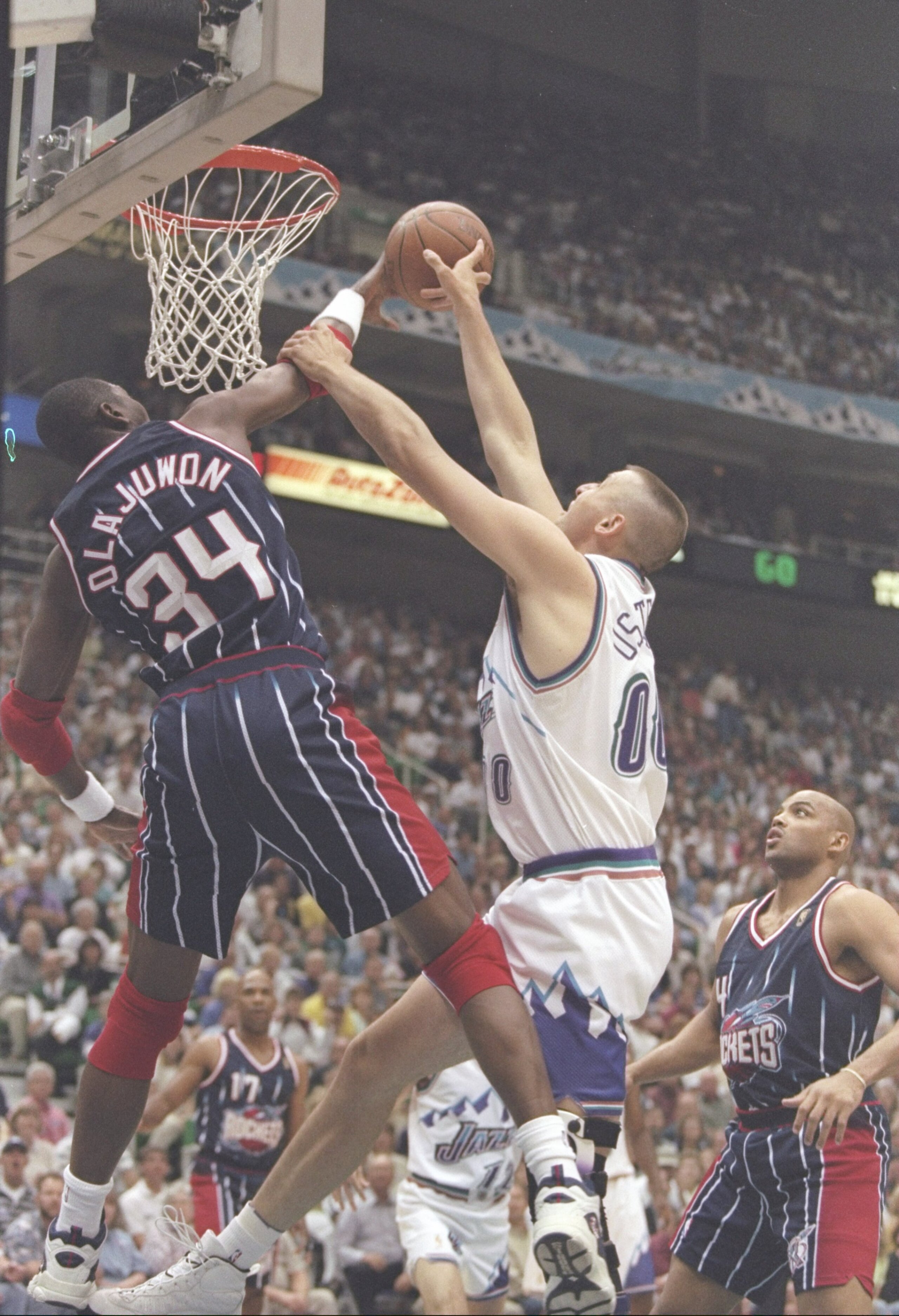 27 May 1997:  Center Hakeem Olajuwon of the Houston Rockets tries to block center Greg Ostertag of the Utah Jazz during a playoff game at the Delta Center in Salt Lake City, Utah.  The Jazz won the game 96-91. Mandatory Credit: Brian Bahr  /Allsport