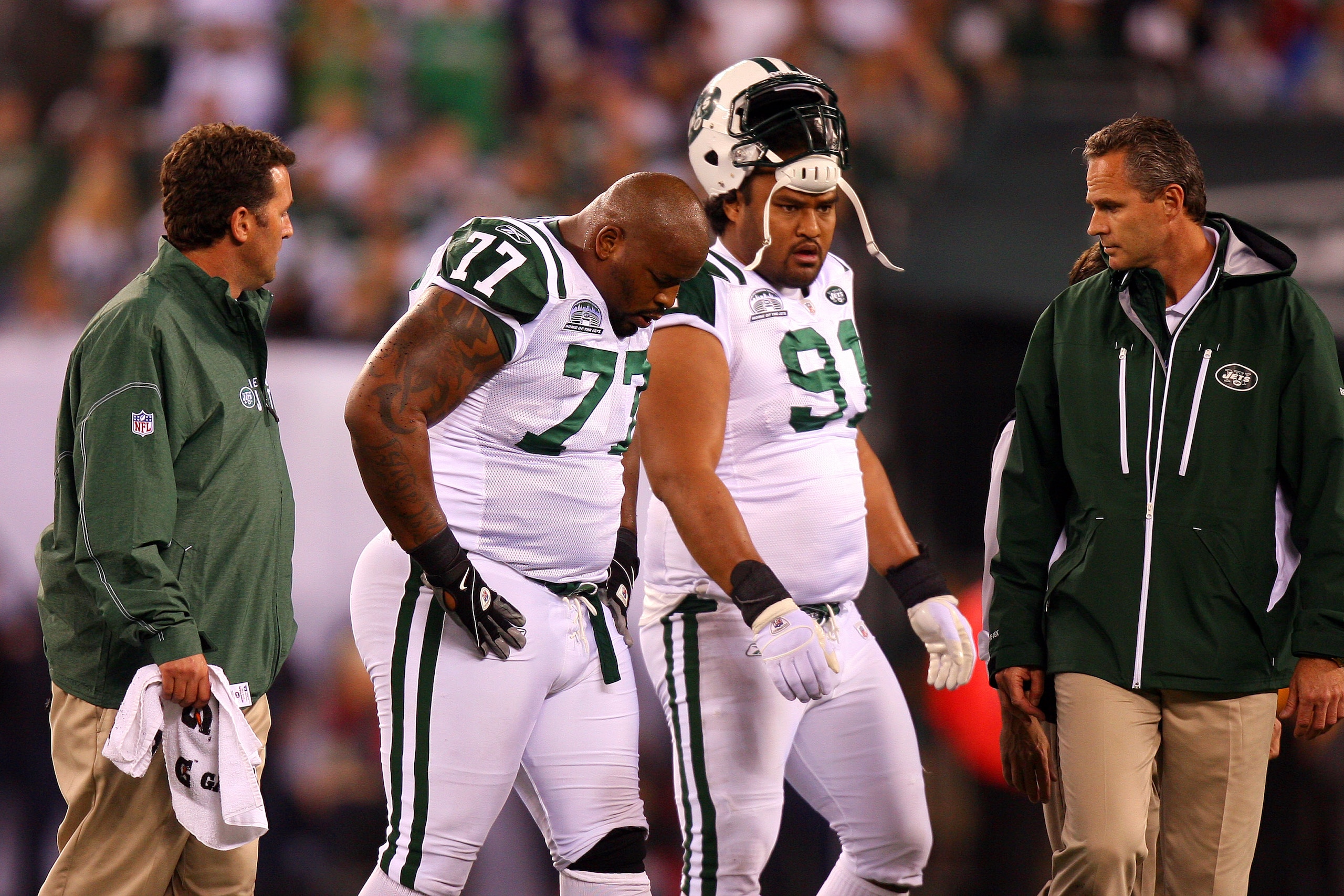EAST RUTHERFORD, NJ - SEPTEMBER 13:  Kris Jenkins #77 of the New York Jets  comes out of the game after getting injured while playing against the Baltimore Ravens as Sione Pouha #91 looks on during their home opener at the New Meadowlands Stadium on Septe