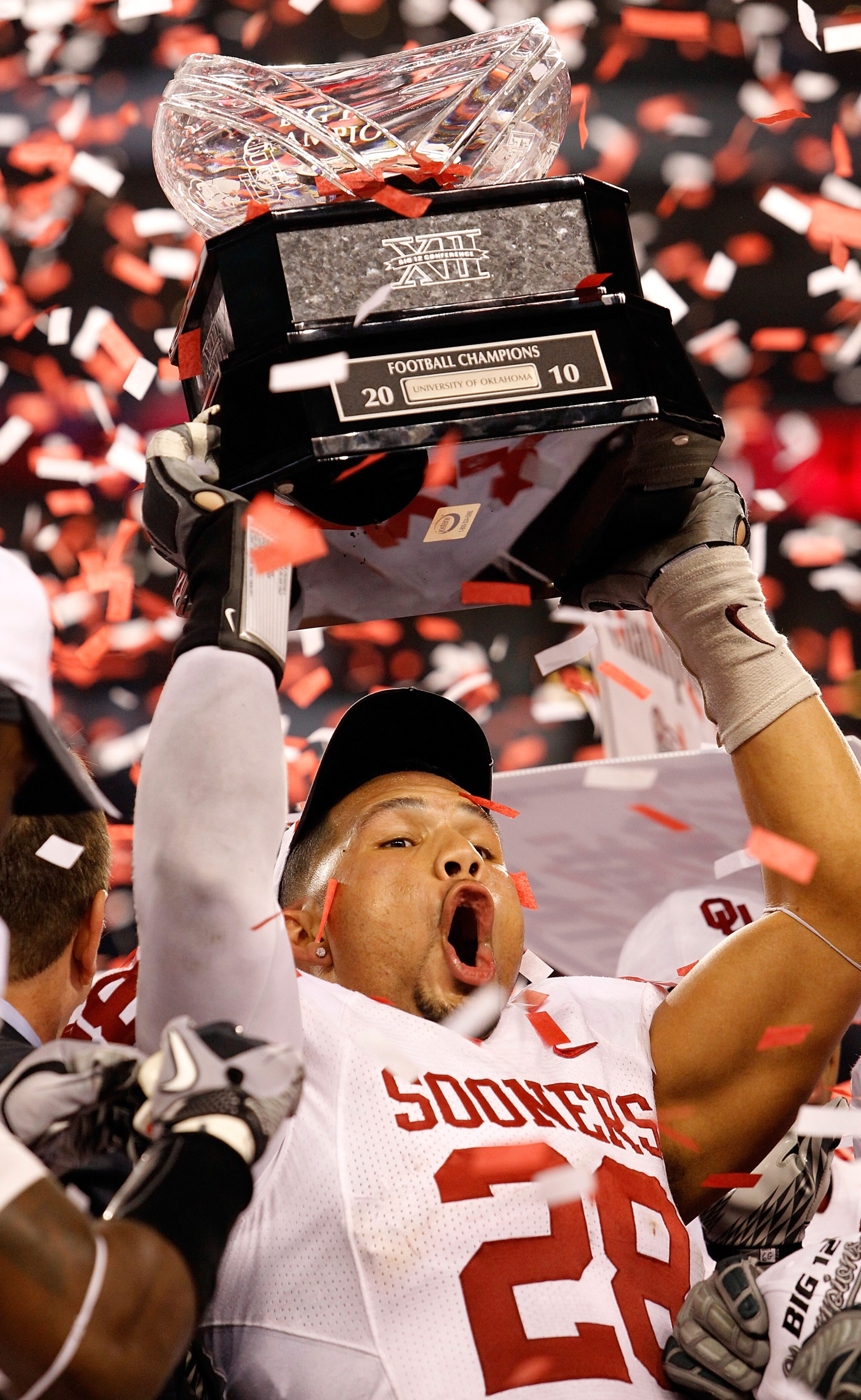 ARLINGTON, TX - DECEMBER 04: Linebacker Travis Lewis #28 of the Oklahoma Sooners celebrates with the Big 12 Championship Trophy after the Sooners beat the Nebraska Cornhuskers 23-20 at Cowboys Stadium on December 4, 2010 in Arlington, Texas. (Photo by T ARLINGTON, TX - DECEMBER 04: Linebacker Travis Lewis #28 of the Oklahoma Sooners celebrates with the Big 12 Championship Trophy after the Sooners beat the Nebraska Cornhuskers 23-20 at Cowboys Stadium on December 4, 2010 in Arlington, Texas. (Photo by T