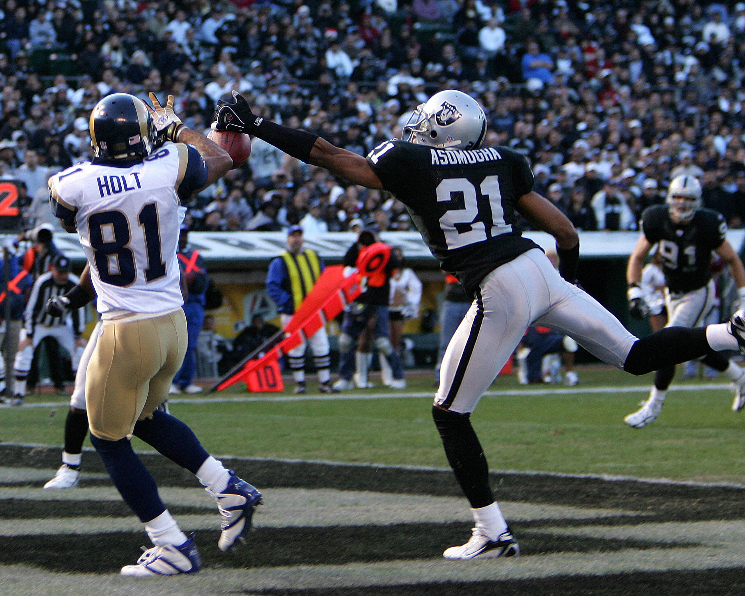 Oakland cornerback Nnamdi Asomugha prevents a touchdown by perfectly deflecting a pass away from St. Louis wide receiver Torry Holt in the Raiders 20-0 loss to the Rams on Sunday, December 17, 2006 at McAfee Coliseum in Oakland, California. (Photo by K. T