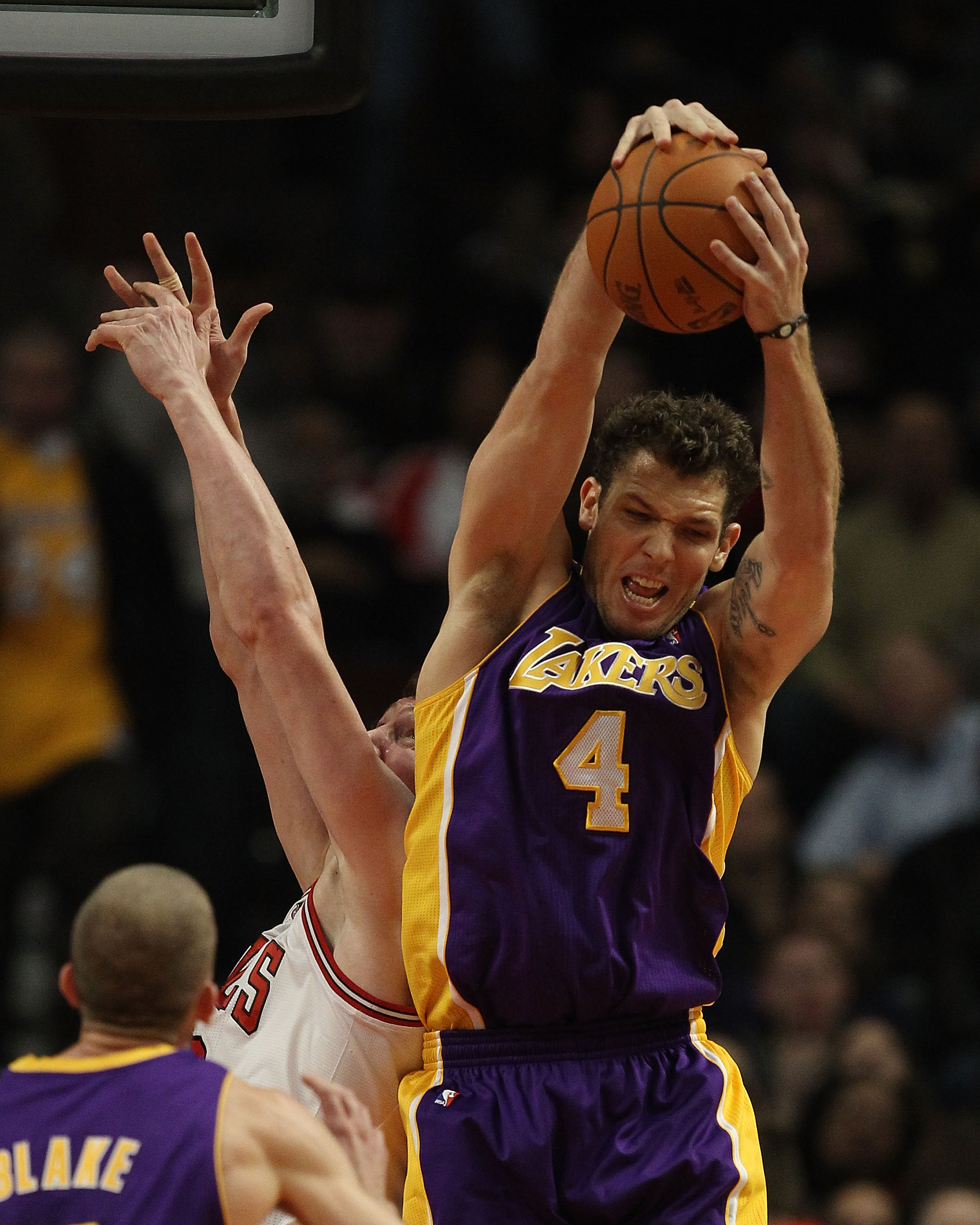CHICAGO, IL - DECEMBER 10: Luke Walton #4 of the Los Angeles Lakers leaps over Omer Asik #3 of the Chicago Bulls to grab a rebound at the United Center on December 10, 2010 in Chicago, Illinois. NOTE TO USER: User expressly acknowledges and agrees that, b