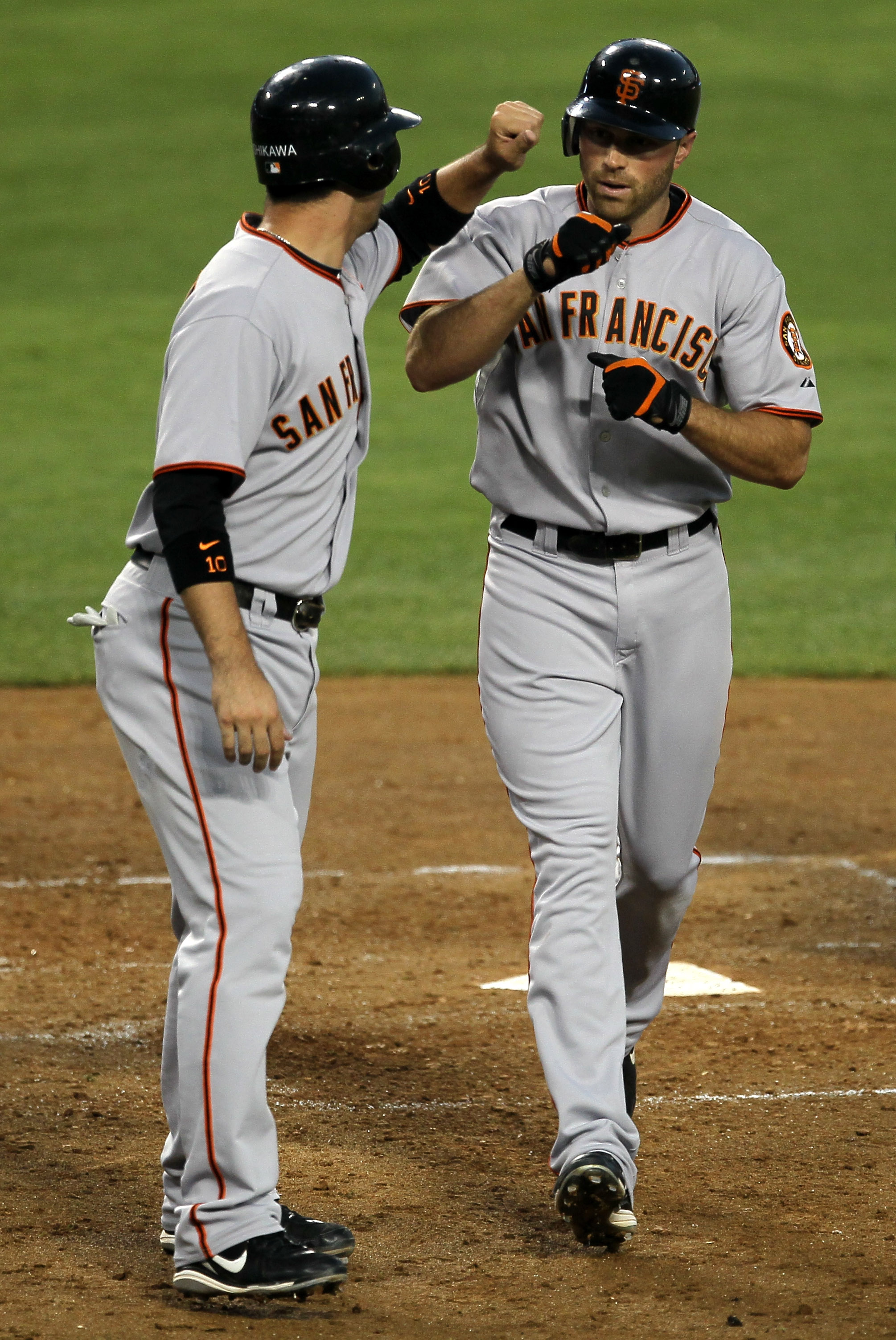 LOS ANGELES - JULY 19: Nate Schierholtz #12 (R) of the San Francisco Giants is greeted by Travis Ishikawa #10 after both score on Schierholtz' fourth inning home run against the Los Angeles Dodgers on July 19, 2010 at Dodger Stadium in Los Angeles, Califo
