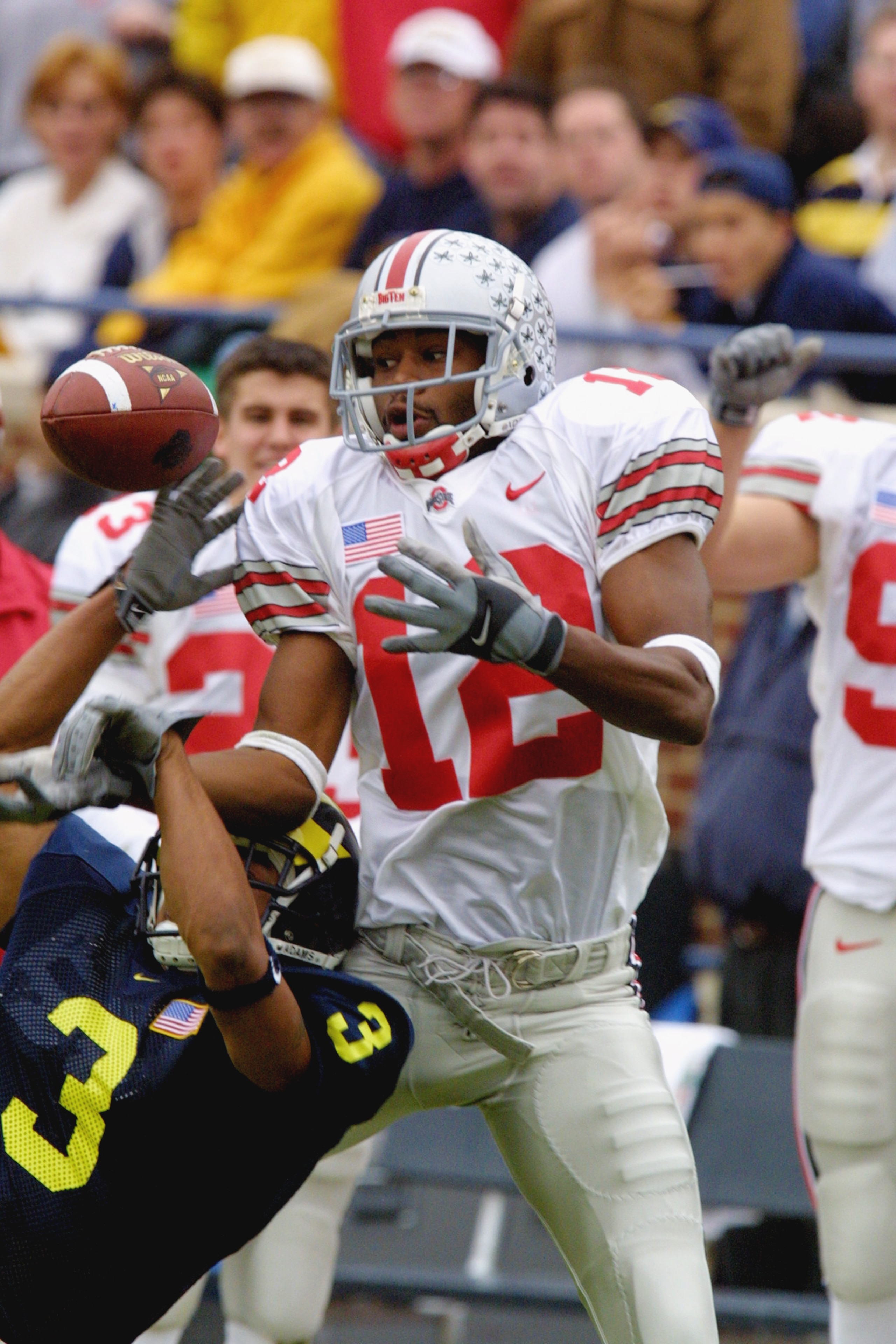 ANN ARBOR, MI - NOVEMBER 24:  Wide receiver Michael Jenkins #12 of the Ohio State Buckeyes leaps for the ball over cornerback Todd Howard #3 of the Michigan Wolverines during the Big Ten Conference football game on November 24, 2001 at Michigan Stadium in