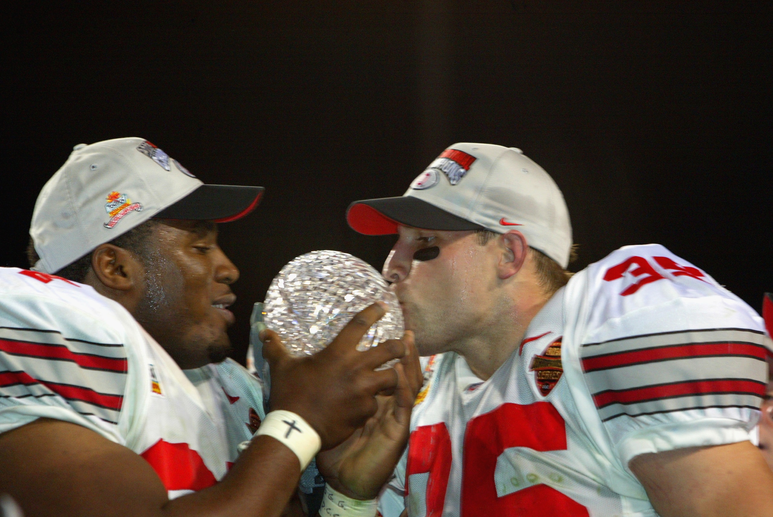 TEMPE, AZ - JANUARY 3:  Kenny Peterson #97 (l) and Matt Wilheim #35 of the Ohio State Buckeyes celebrate with the National Championship trophy after defeating the Miami Hurricanes 31-24 in double overtime the Tostitos Fiesta Bowl on January 3, 2003 at Sun