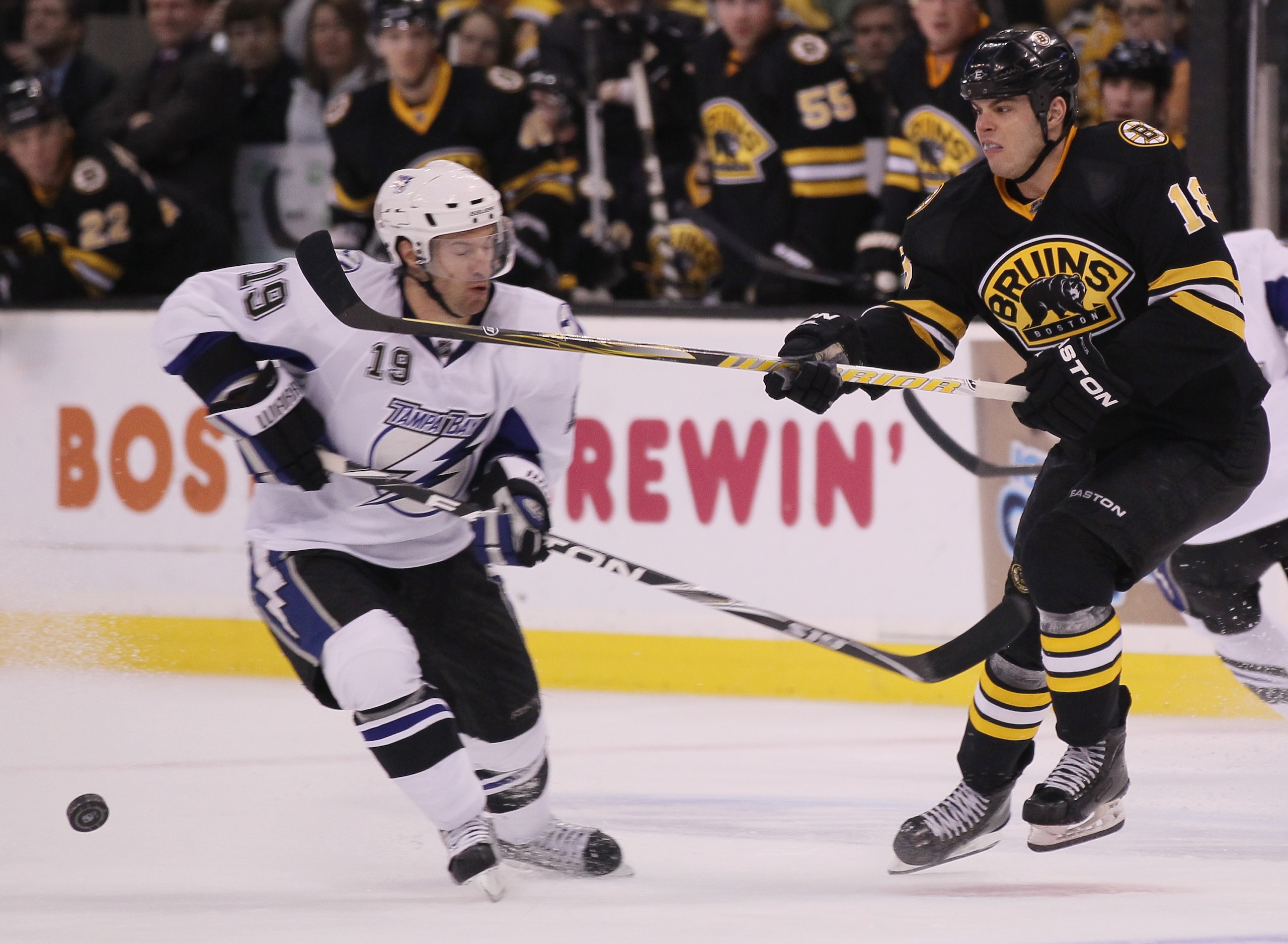 BOSTON, MA - MARCH 03:  Nathan Horton #18 of the Boston Bruins clears the puck as Dominic Moore #19 of the Tampa Bay Lightning nearly is hit on March 3, 2011 at the TD Garden in Boston, Massachusetts.  (Photo by Elsa/Getty Images)
