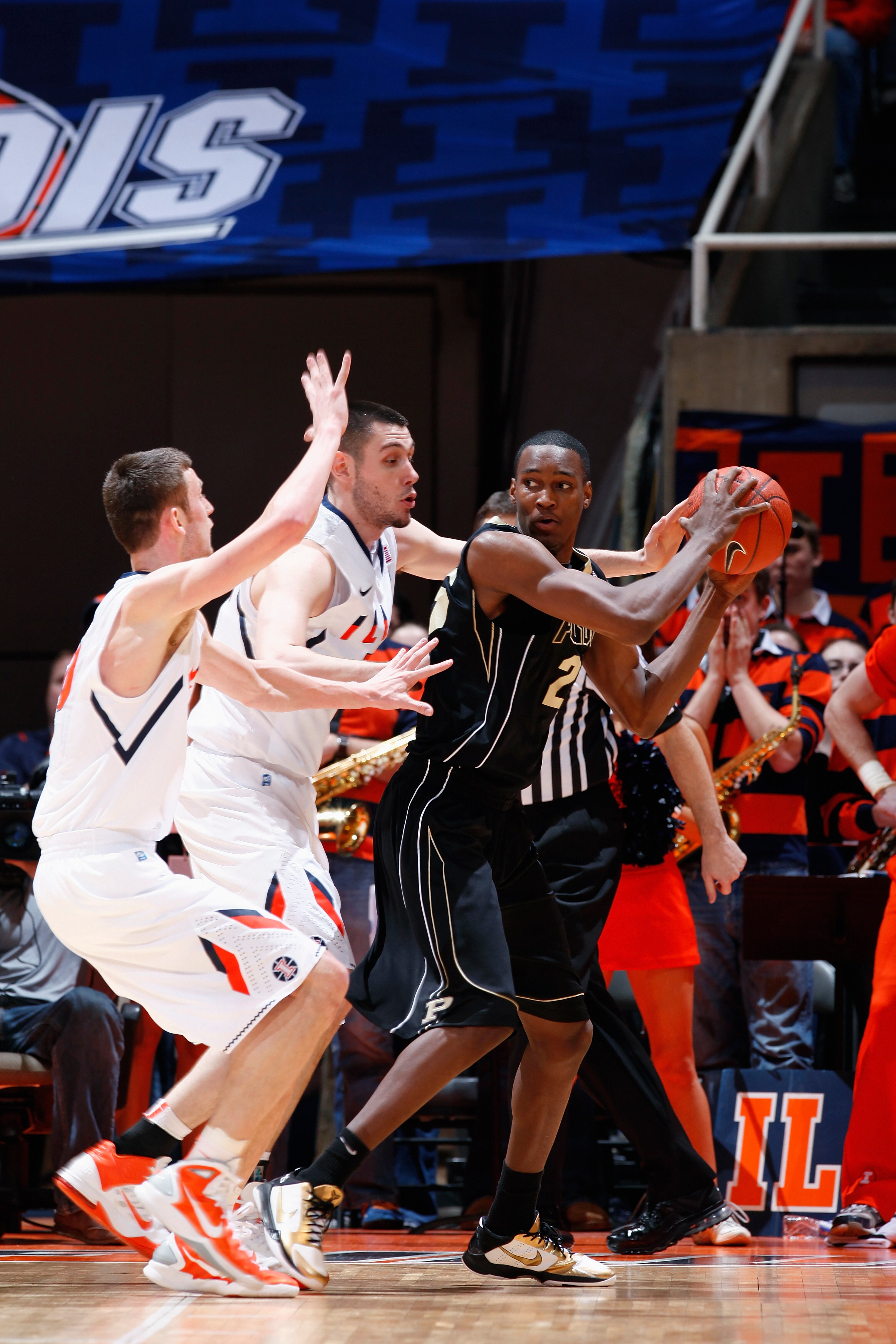 CHAMPAIGN, IL - FEBRUARY 13: JaJuan Johnson #25 of the Purdue Boilermakers looks to the basket while being defended by Mike Tisdale #54 and Bill Cole #30 of the Illinois Fighting Illini at Assembly Hall on February 13, 2011 in Champaign, Illinois. Purdue