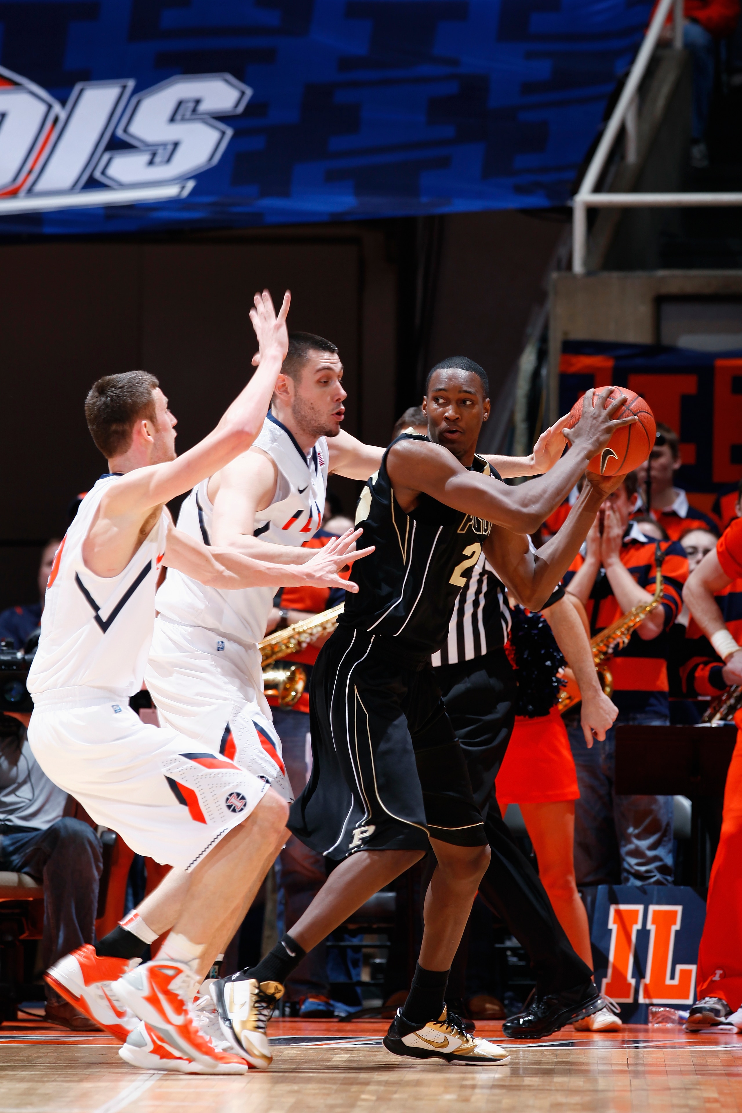 CHAMPAIGN, IL - FEBRUARY 13: JaJuan Johnson #25 of the Purdue Boilermakers looks to the basket while being defended by Mike Tisdale #54 and Bill Cole #30 of the Illinois Fighting Illini at Assembly Hall on February 13, 2011 in Champaign, Illinois. Purdue