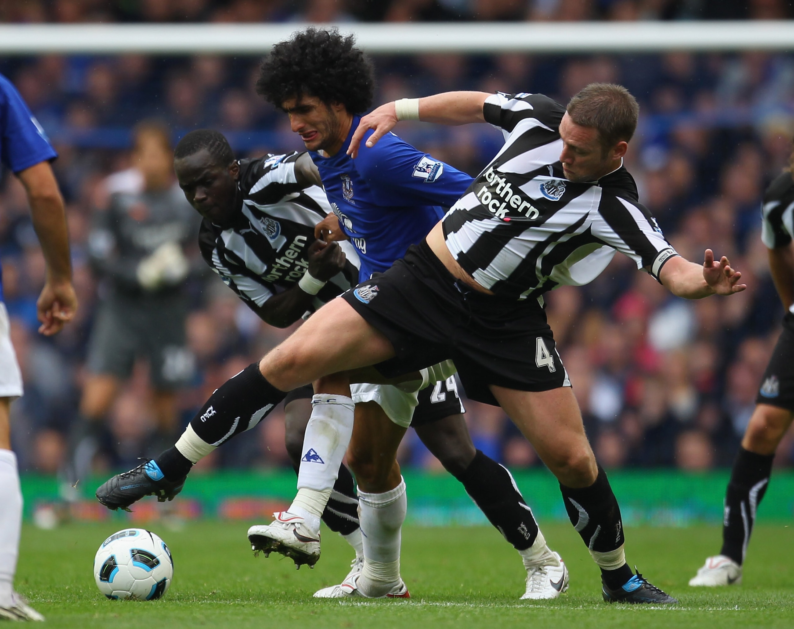 LIVERPOOL, ENGLAND - SEPTEMBER 18:  Kevin Nolan and Cheik Tiote of Newcastle United tackle Marouane Fellaini of Everton during the Barclays Premier League match between Everton and Newcastle United at Goodison Park on September 18, 2010 in Liverpool, Engl