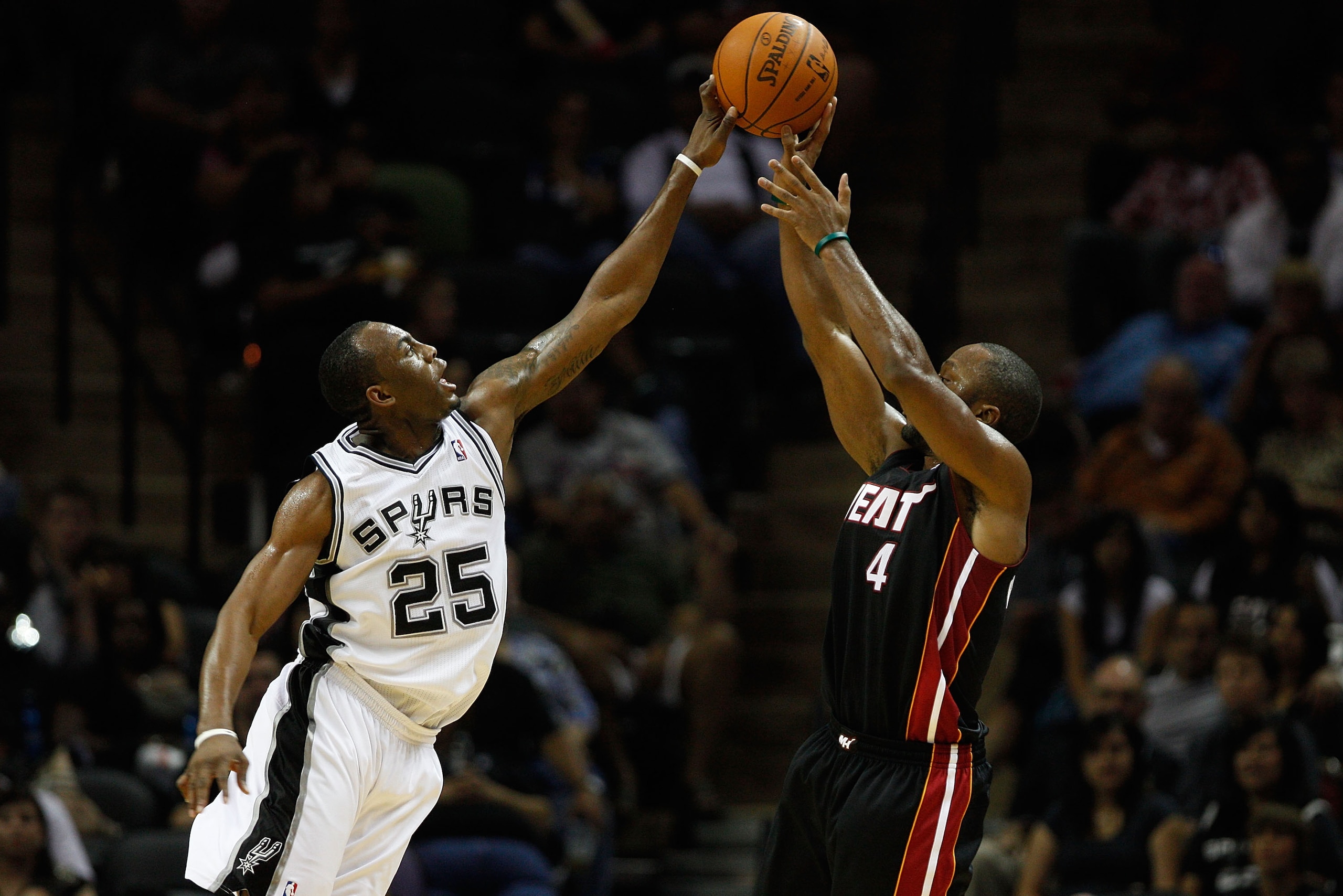 SAN ANTONIO - OCTOBER 09:  Kenny Hasbrouck #4 of the Miami Heat has a shot blocked by James Anderson #25 of the San Antonio Spurs at the AT&T Center on October 9, 2010 in San Antonio, Texas.  NOTE TO USER: User expressly acknowledges and agrees that, by d