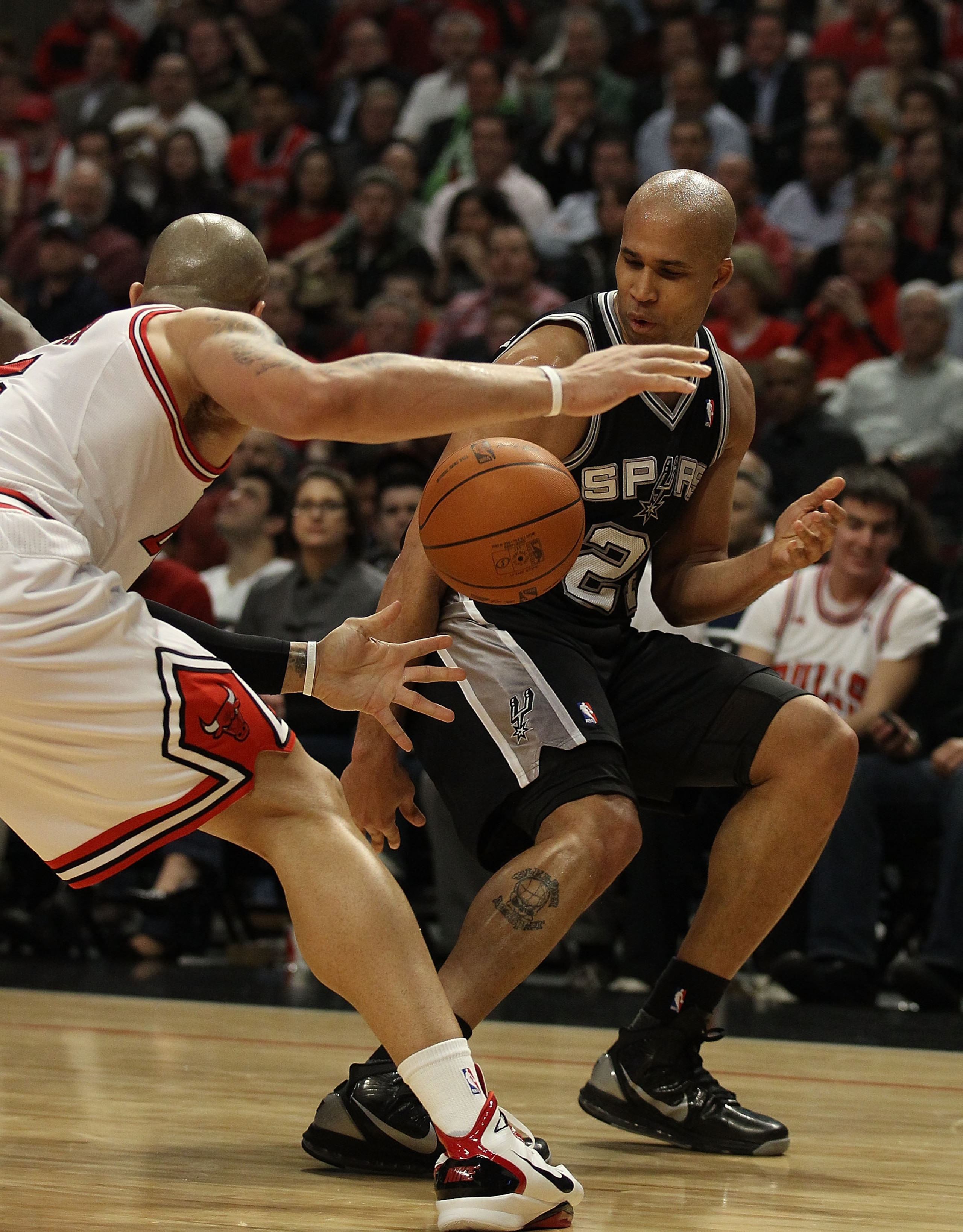CHICAGO, IL - FEBRUARY 17: Richard Jefferson #24 of the San Antonio Spurs looses control of the ball and bounces it off the leg of Carlos Boozer #5 of the Chicago Bulls at the United Center on February 17, 2011 in Chicago, Illinois. NOTE TO USER: User exp