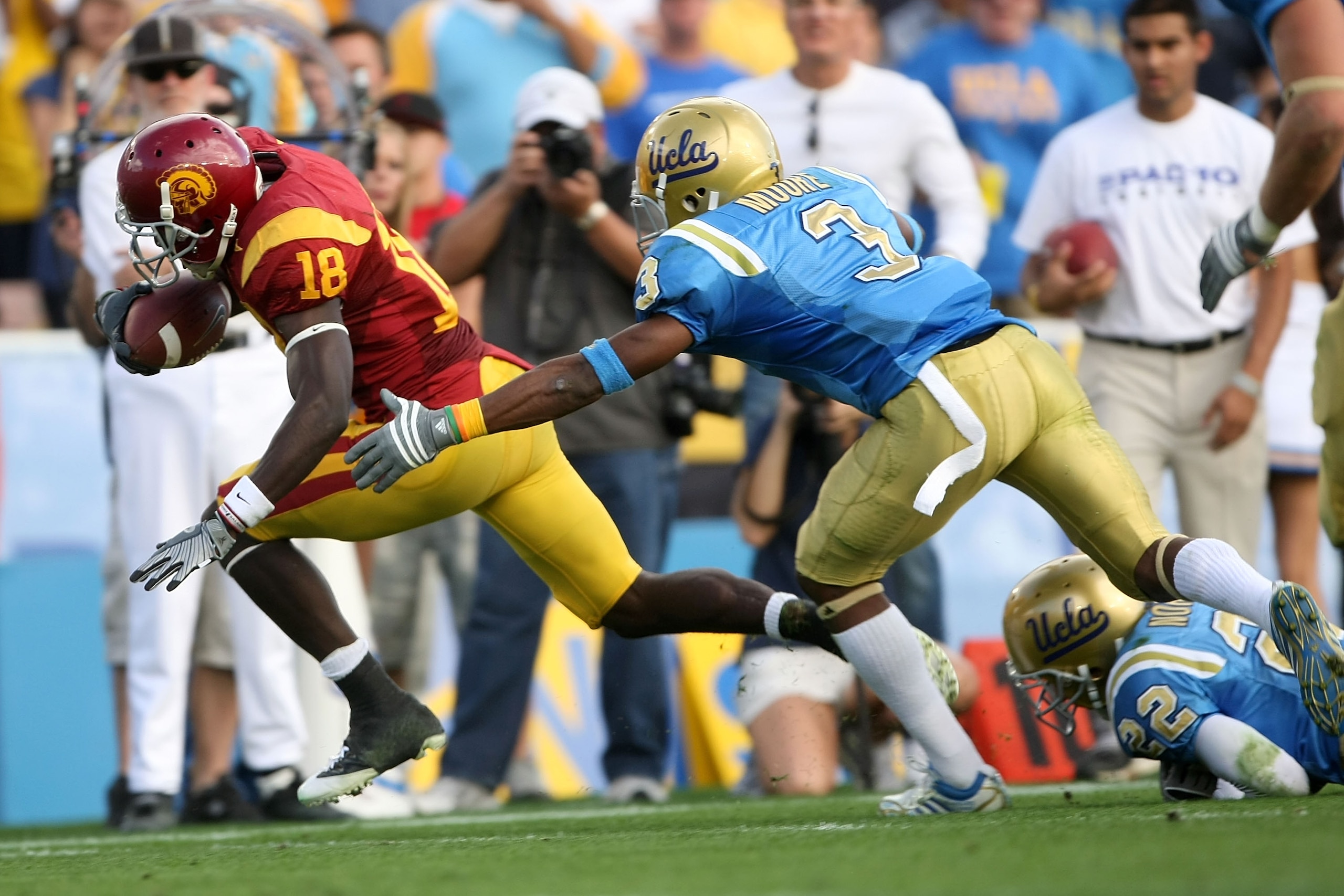 PASADENA, CA - DECEMBER 06:  Damian Williams #18 of the USC Trojans runs into the end zone for a touchdown past Michael Norris #22 and Rahim Moore #3 of the UCLA Bruins in the first half of the game on December 6, 2008 at the Rose Bowl in Pasadena, Califo