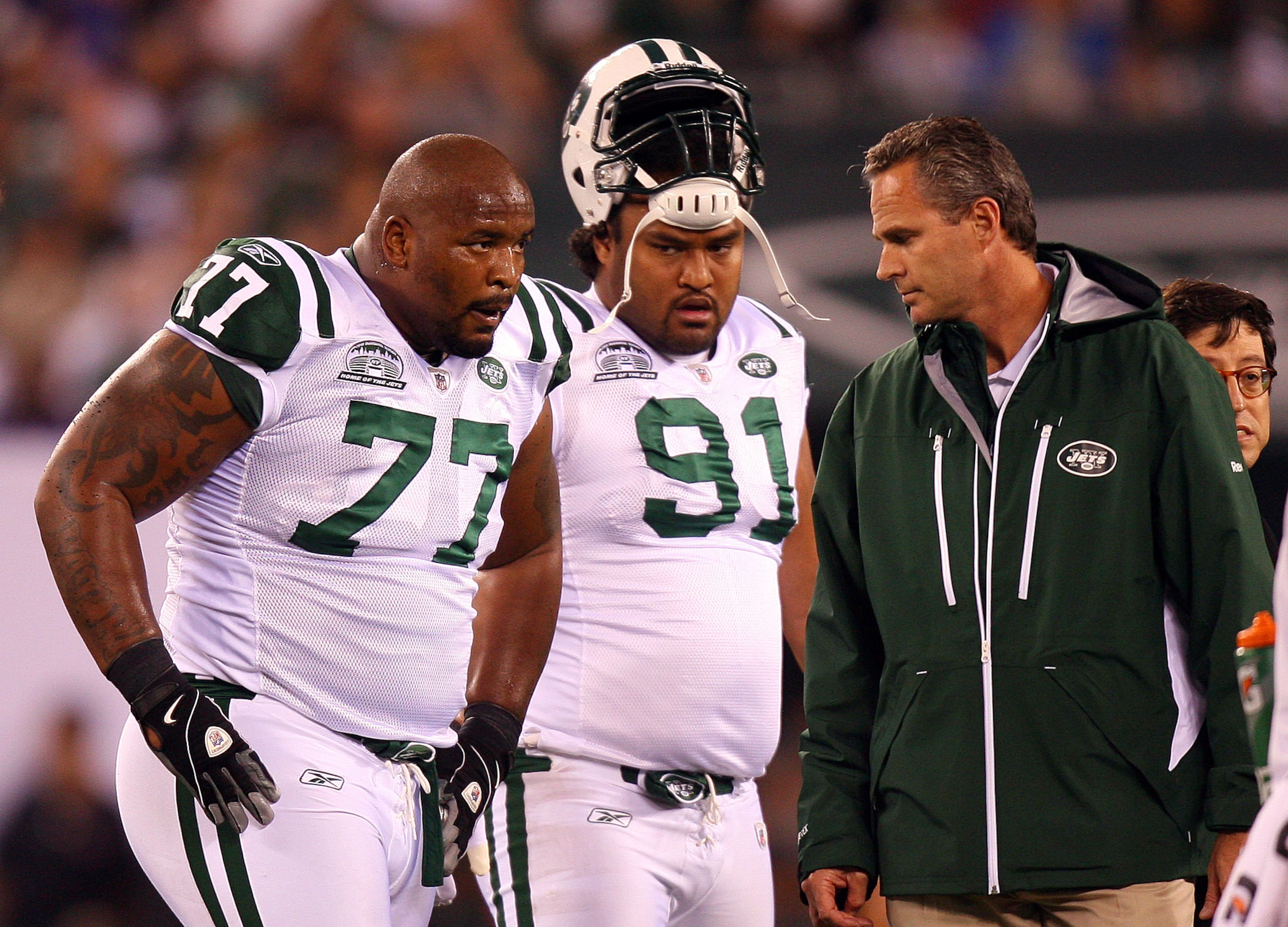 EAST RUTHERFORD, NJ - SEPTEMBER 13:  Kris Jenkins #77 of the New York Jets  comes out of the game after getting injured while playing against the Baltimore Ravens as Sione Pouha #91 looks on during their home opener at the New Meadowlands Stadium on Septe