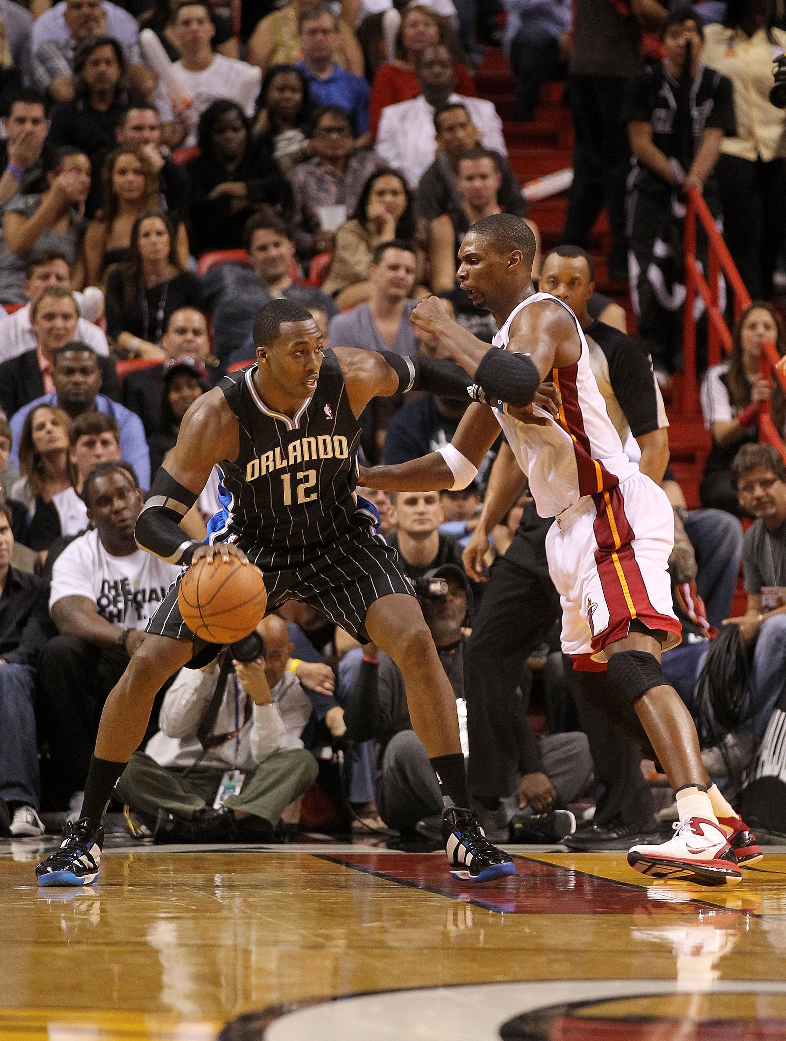 MIAMI, FL - MARCH 03:  Dwight Howard #12 of the Orlando Magic drives against Chris Bosh #1 of the Miami Heat during a game at American Airlines Arena on March 3, 2011 in Miami, Florida. NOTE TO USER: User expressly acknowledges and agrees that, by downloa