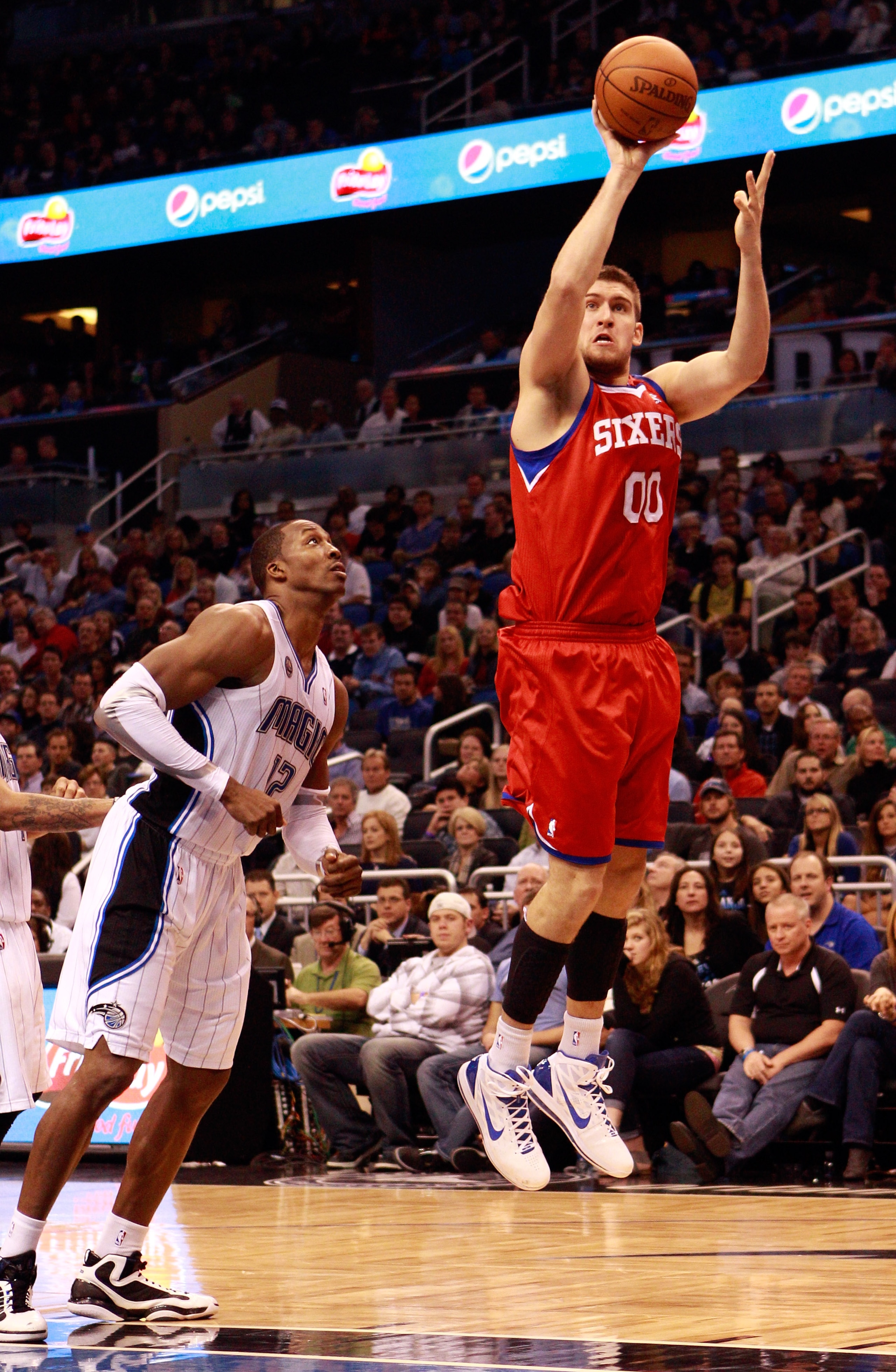 ORLANDO, FL - DECEMBER 18:  Spencer Hawes #00 of the Philadelphia 76ers attempts a shot against Dwight Howard #12 of the Orlando Magic during the game at Amway Arena on December 18, 2010 in Orlando, Florida.  NOTE TO USER: User expressly acknowledges and