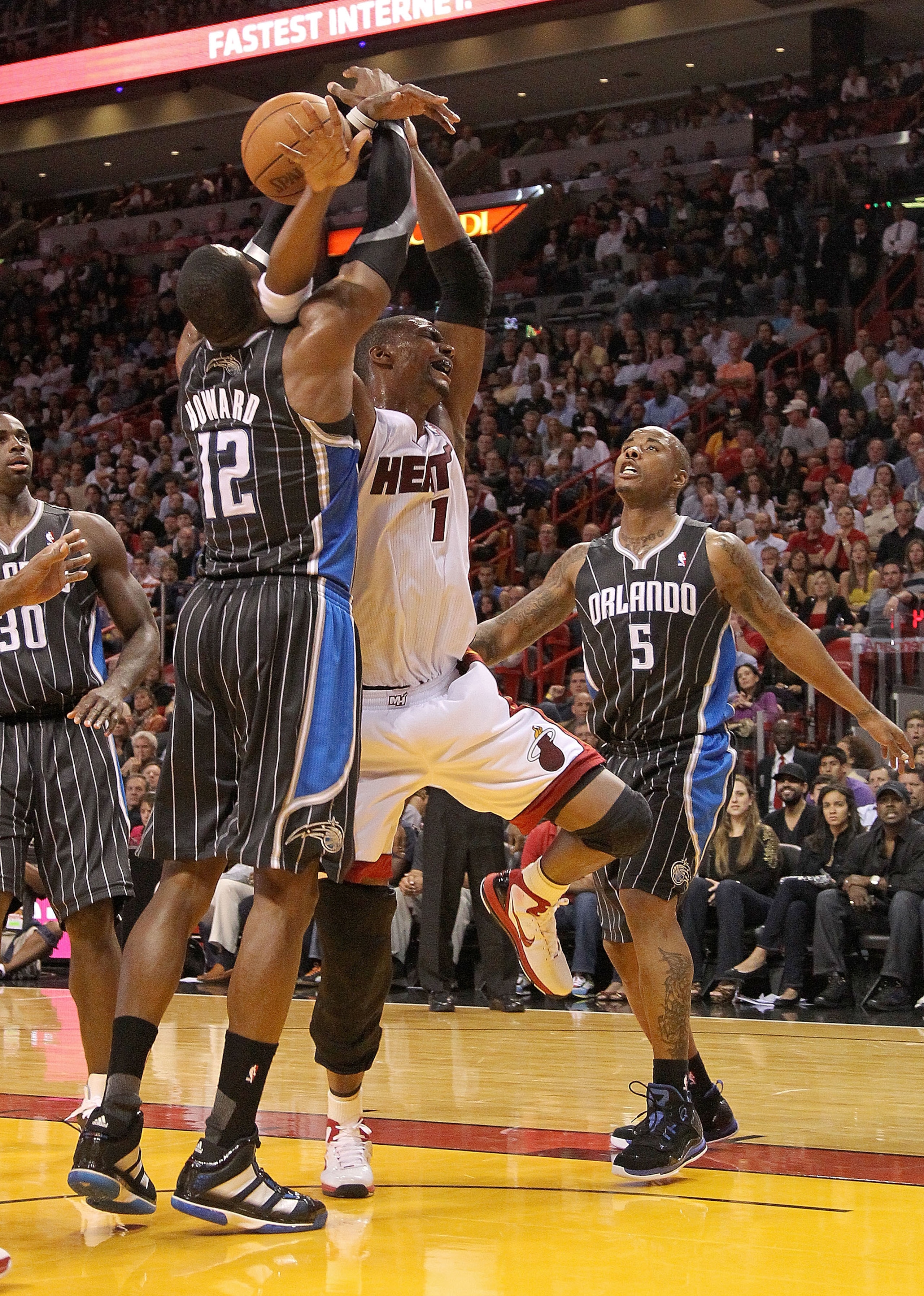 MIAMI, FL - MARCH 03: Chris Bosh #1 of the Miami Heat is fouled by Dwight Howard #12 of the Orlando Magic during a game at American Airlines Arena on March 3, 2011 in Miami, Florida. NOTE TO USER: User expressly acknowledges and agrees that, by downloadin