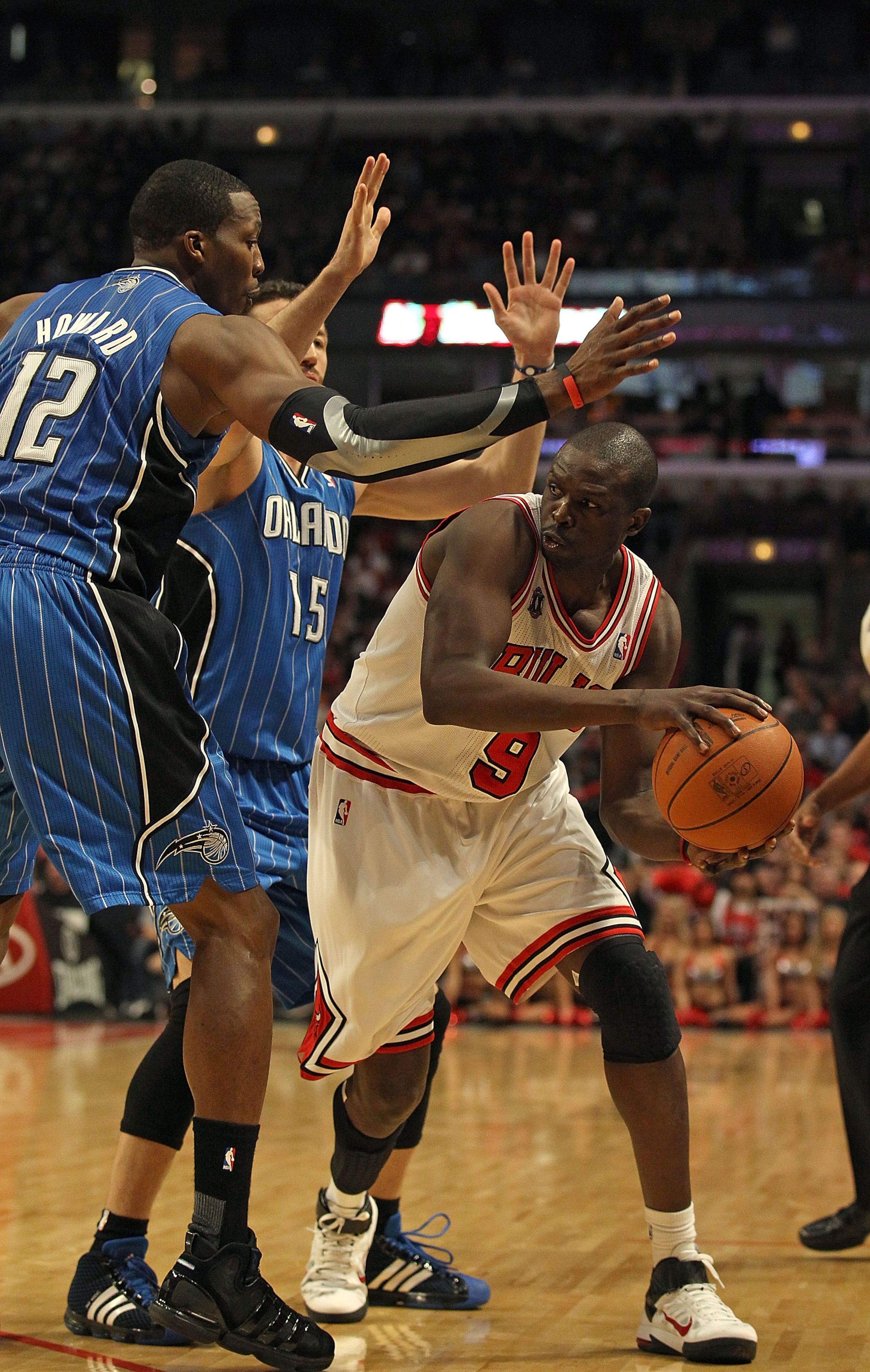 CHICAGO, IL - JANUARY 28: Loul Deng #9 of the Chicago Bulls looks to pass under pressure from Dwight Howard #12 and Hedo Turkoglu #15 of the Orlando Magic at the United Center on January 28, 2011 in Chicago, Illinois. The Bulls defeated the Magic 99-90. N