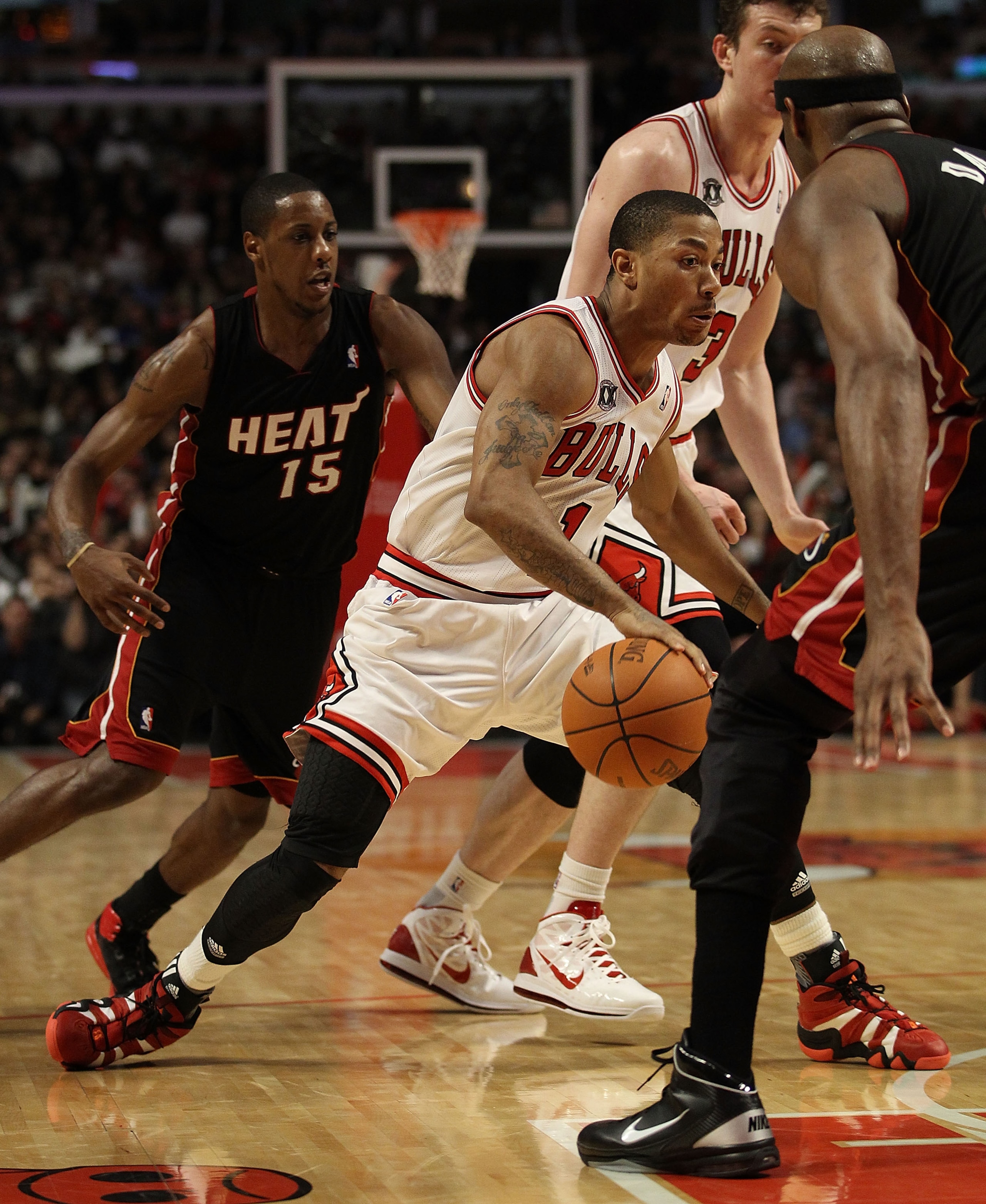 CHICAGO, IL - FEBRUARY 24: Derrick Rose #1 of the Chicago Bulls drives between Mario Chalmers #15 and Erick Dampier #25 of the Miami Heat at the United Center on February 24, 2011 in Chicago, Illinois. The Bulls defeated the Heat 93-89. NOTE TO USER: User