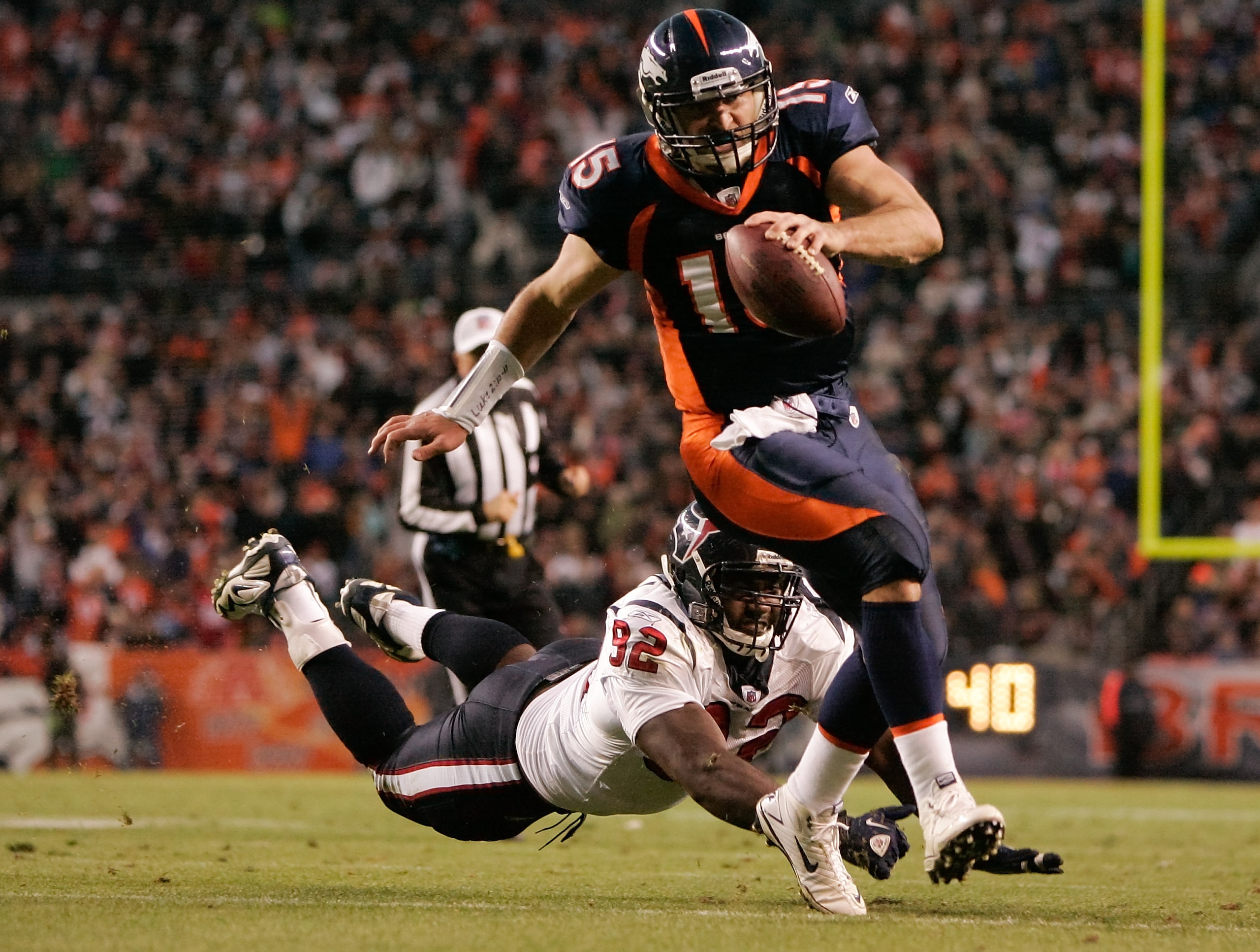 DENVER - DECEMBER 26:  Quarterback Tim Tebow #15 of the Denver Broncos escapes a diving effort by defensive tackle Earl Mitchell #92 of the Houston Texans on his way to scoring the game-winning touchdown in the fourth quarter at INVESCO Field at Mile High