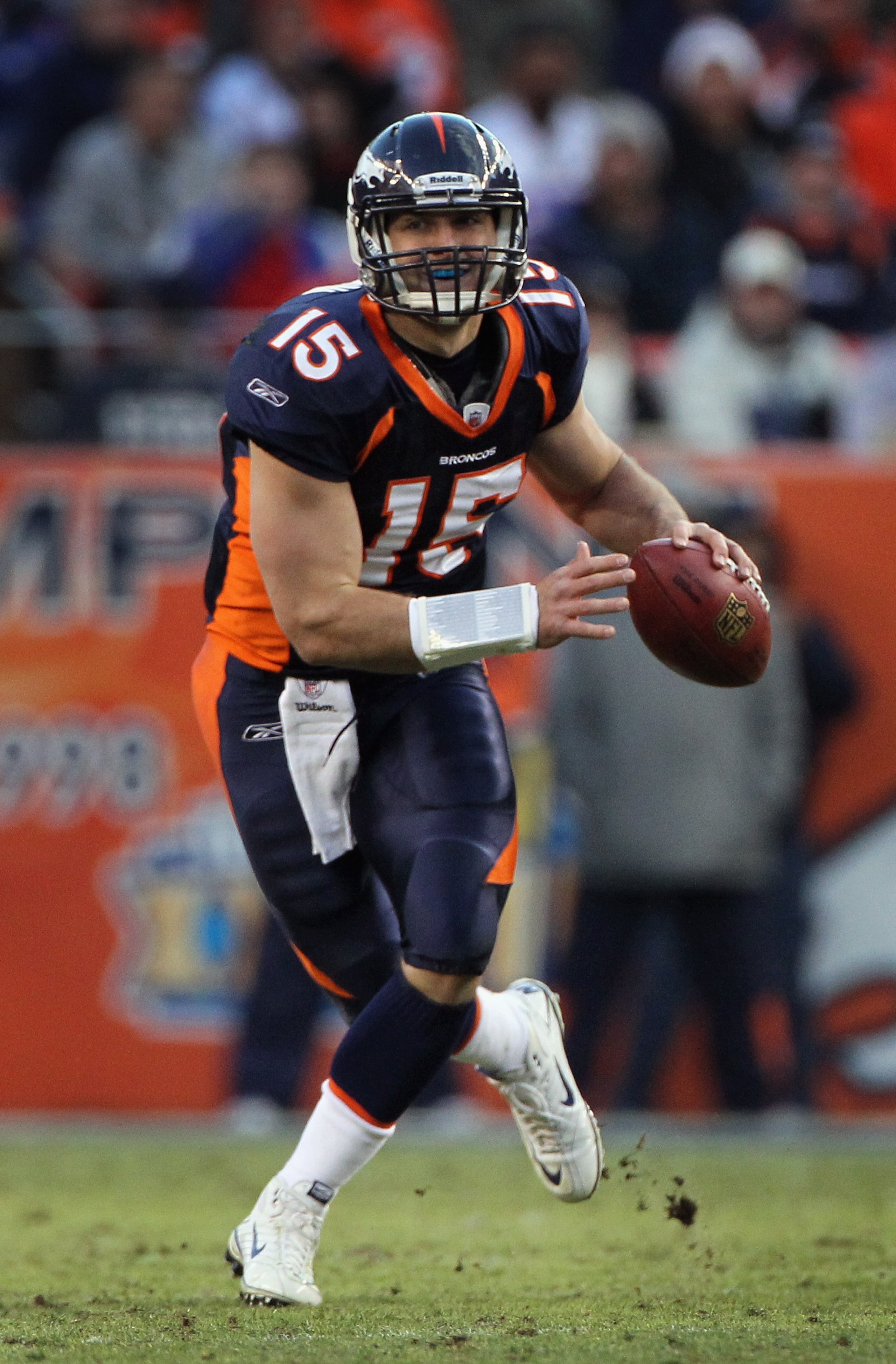 DENVER - DECEMBER 26:  Quarterback Tim Tebow #15 of the Denver Broncos rolls out and looks to deliver a pass against the Houston Texas at INVESCO Field at Mile High on December 26, 2010 in Denver, Colorado. The Broncos defeated the Texans 24-23.  (Photo b