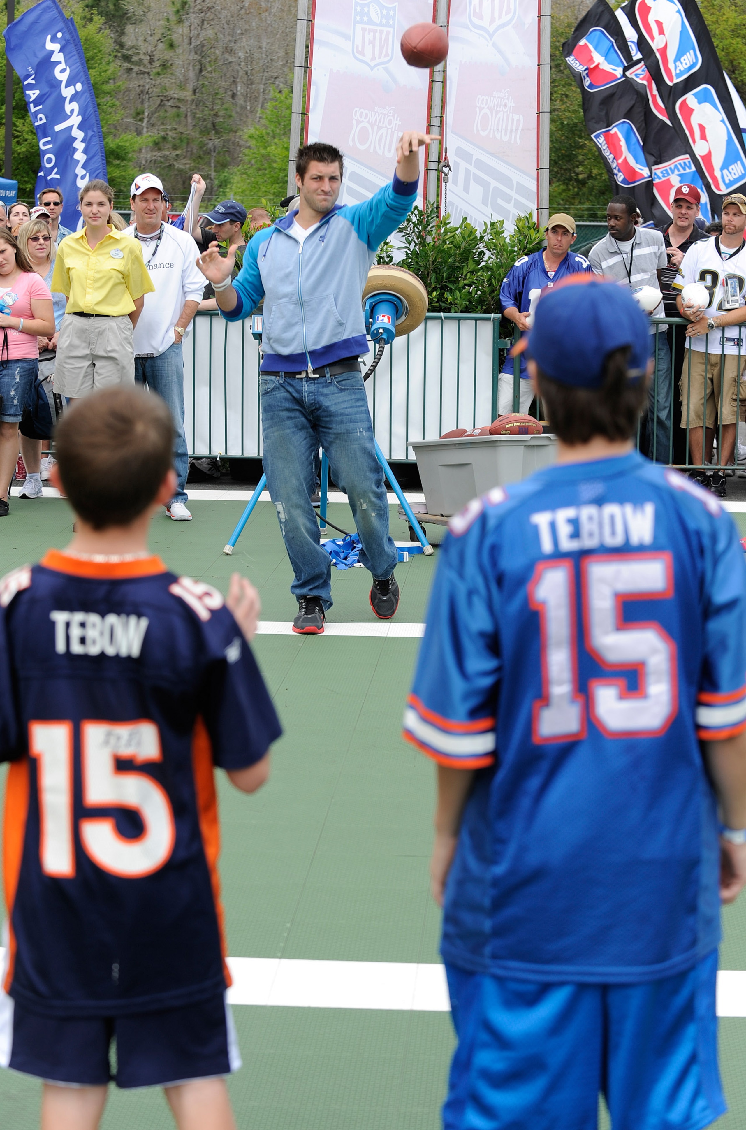 LAKE BUENA VISTA, FL - MAR 04: In this handout image provided by Disney Parks,  Denver Broncos quarterback Tim Tebow throws a football to two young fans at Disney's Hollywood Studios park in Lake Buena Vista, Florida on March 4, 2011.   Tebow, a former He