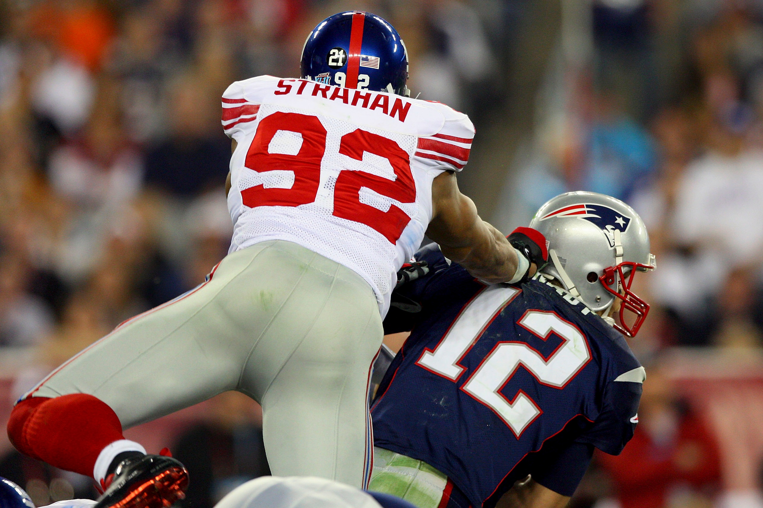 GLENDALE, AZ - FEBRUARY 03:  Quarterback Tom Brady #12 of the New England Patriots is hit hard by Michael Strahan #92 of the New York Giants in the second quarter during Super Bowl XLII on February 3, 2008 at the University of Phoenix Stadium in Glendale,