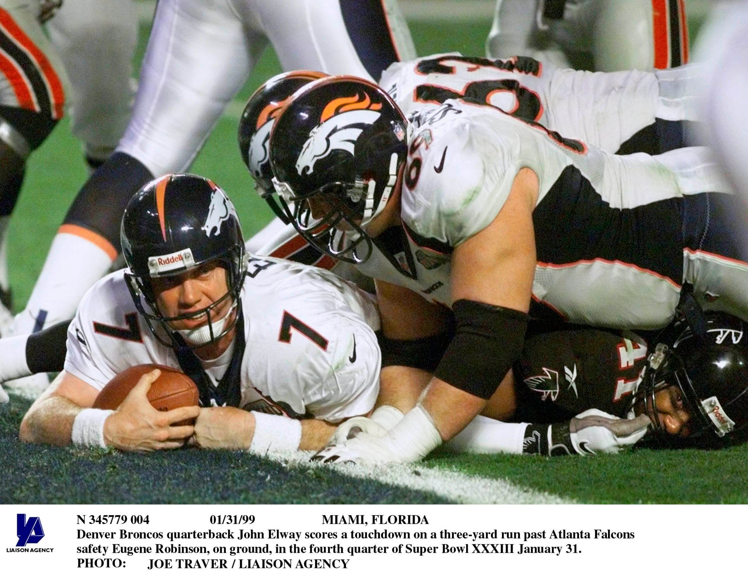 Miami,31Jan99 - Denver Broncos Quarterback John Elway Scores A Touchdown On A Three-Yard Run Past Atlanta Falcons Safety Eugene Robinson, On Ground, In The Fourth Quarter Of Super Bowl Xxxiii January 31. (Photo By Pool/Getty Images)