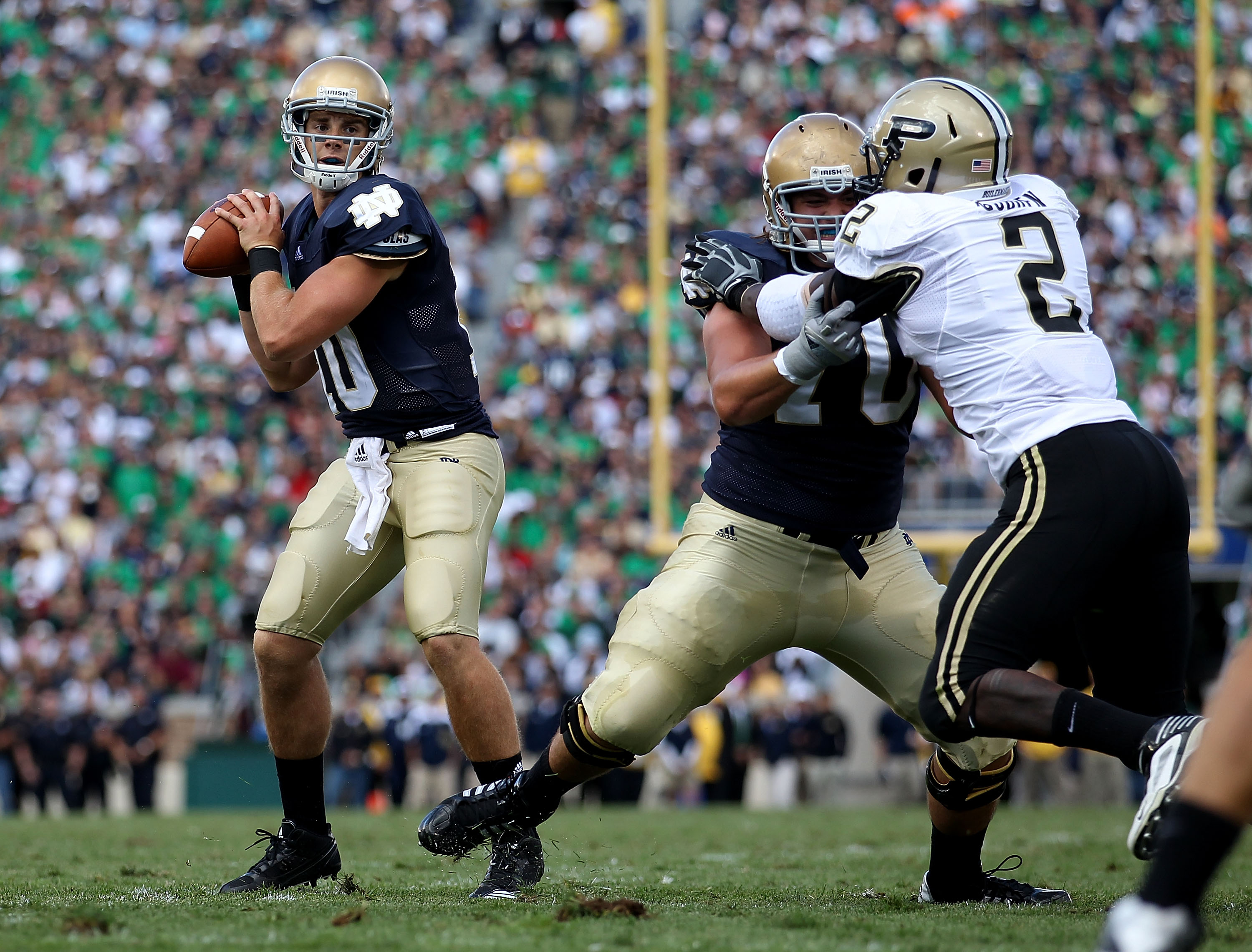 SOUTH BEND, IN - SEPTEMBER 04: Dayne Crist #10 of the Notre Dame Fighting Irish looks for a receiver as teammate Zack Martin #70 blocks Gerald Gooden #2 of the Purdue Boilermakers at Notre Dame Stadium on September 4, 2010 in South Bend, Indiana. Notre Da SOUTH BEND, IN - SEPTEMBER 04: Dayne Crist #10 of the Notre Dame Fighting Irish looks for a receiver as teammate Zack Martin #70 blocks Gerald Gooden #2 of the Purdue Boilermakers at Notre Dame Stadium on September 4, 2010 in South Bend, Indiana. Notre Da