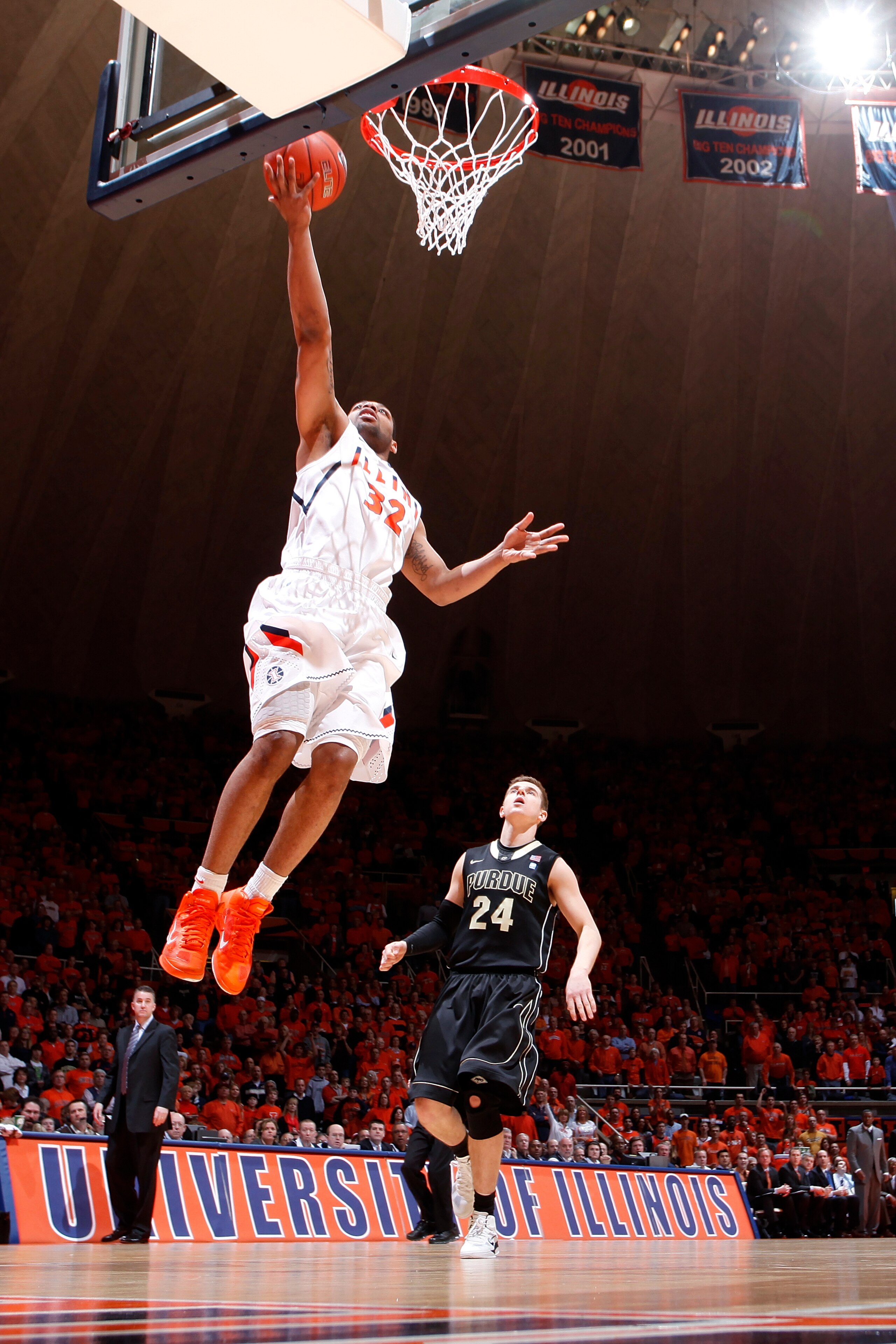 CHAMPAIGN, IL - FEBRUARY 13: Demetri McCamey #32 of the Illinois Fighting Illini lays the ball in on a fast break ahead of Ryne Smith #24 of the Purdue Boilermakers at Assembly Hall on February 13, 2011 in Champaign, Illinois. Purdue defeated Illinois 81-